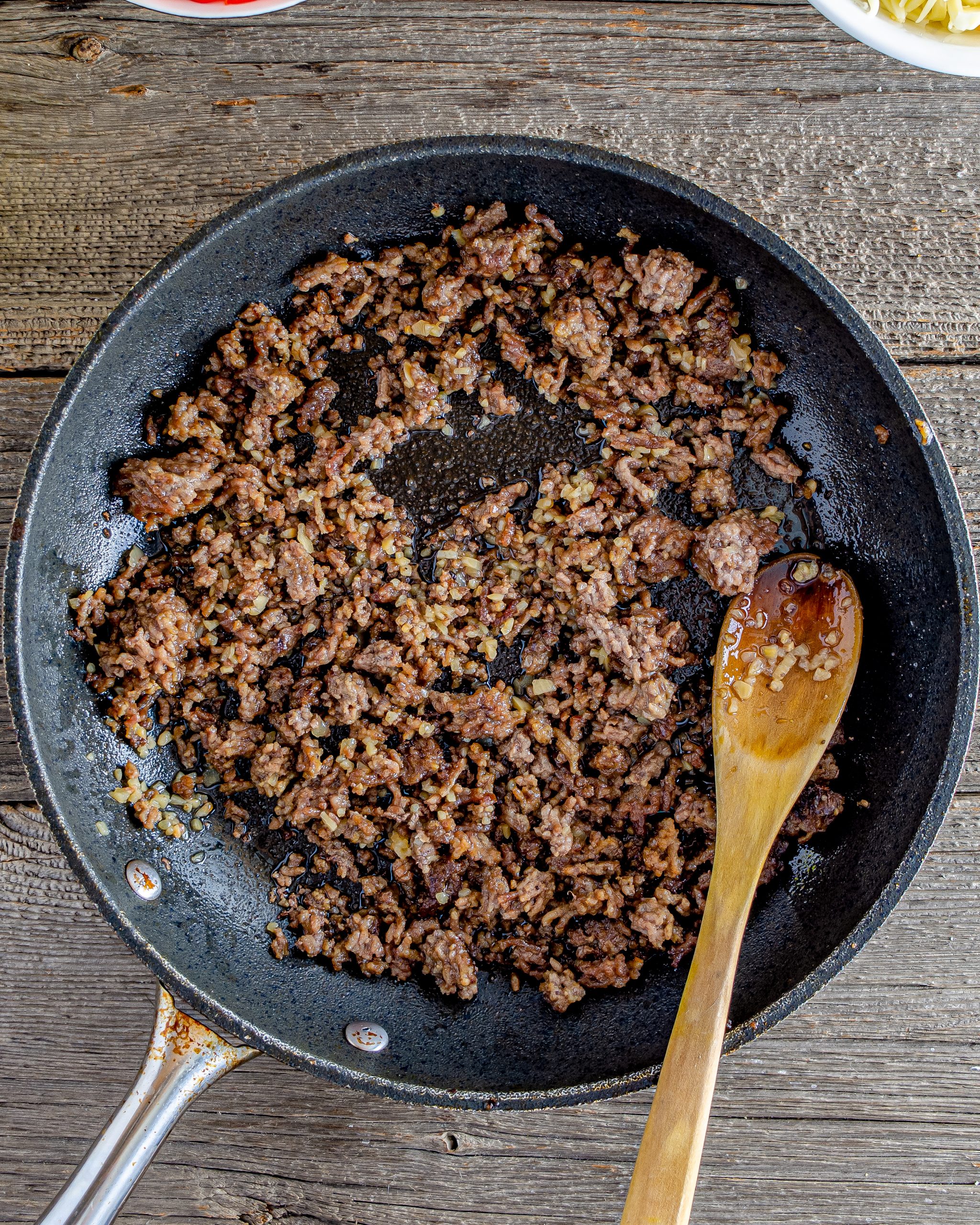 Place the ground beef, onions, and peppers in a large high-sided skillet over medium-high heat. 