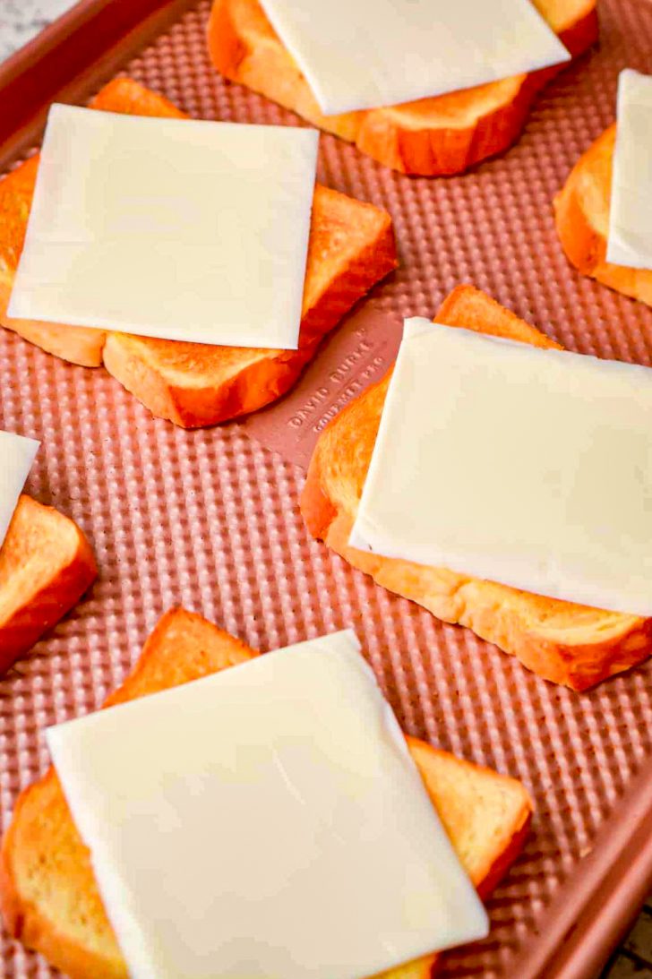Top each piece of toast with a slice of American cheese and place the baking sheet under the broiler for 30 seconds