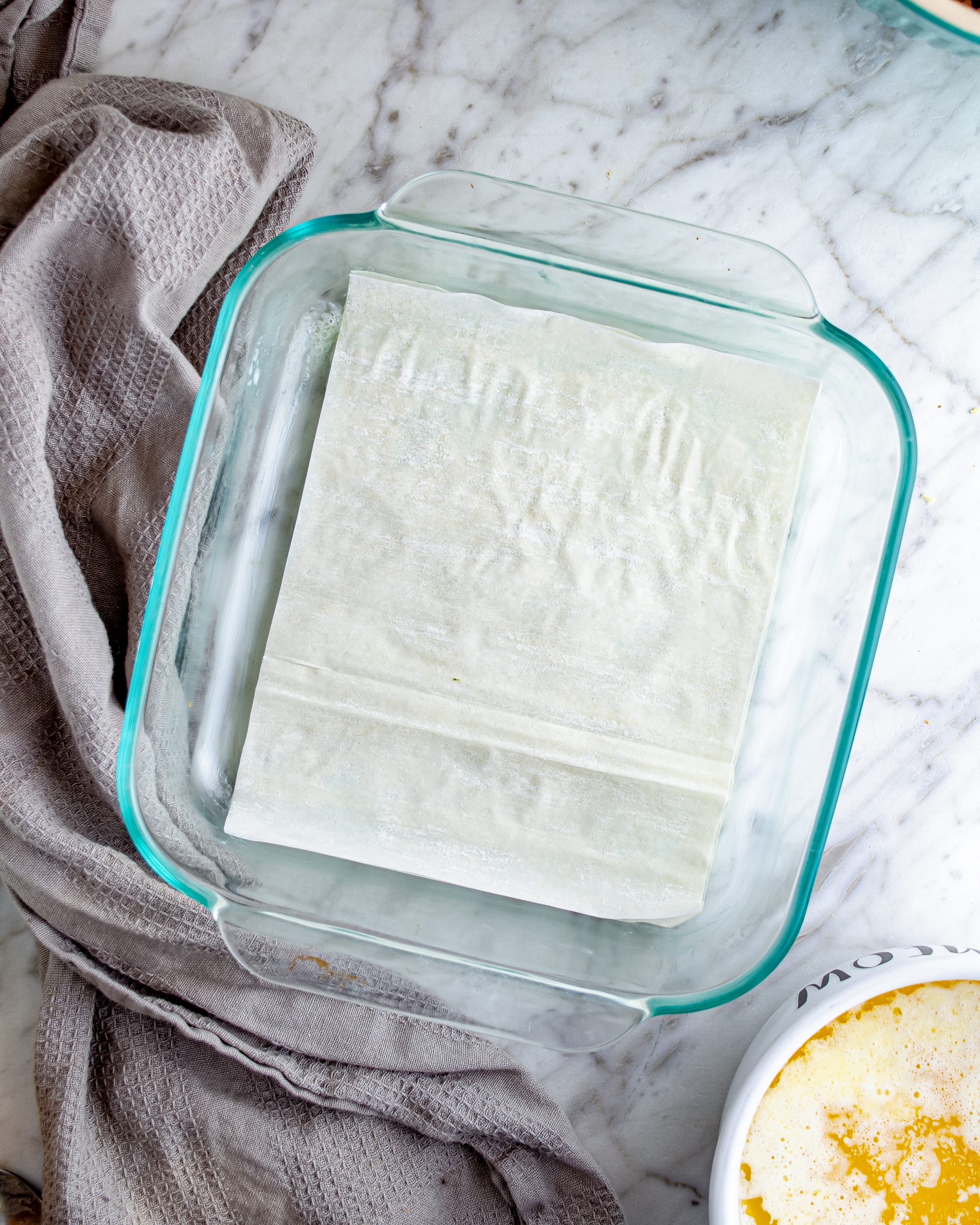 Place a layer of phyllo dough into the bottom of the baking dish.