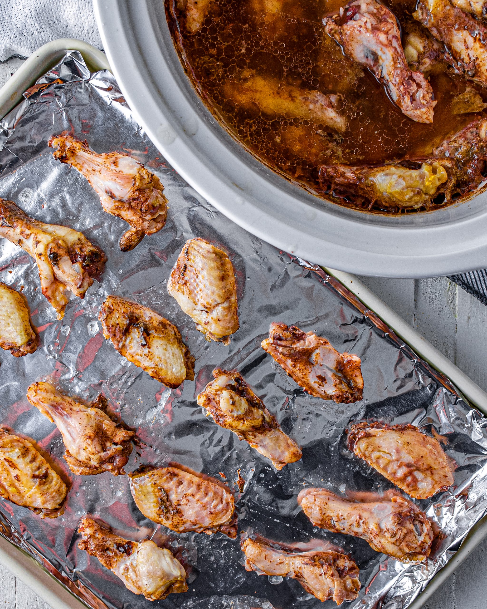 When finished in the slow cooker, place the wings onto an aluminum foil-lined baking sheet. 