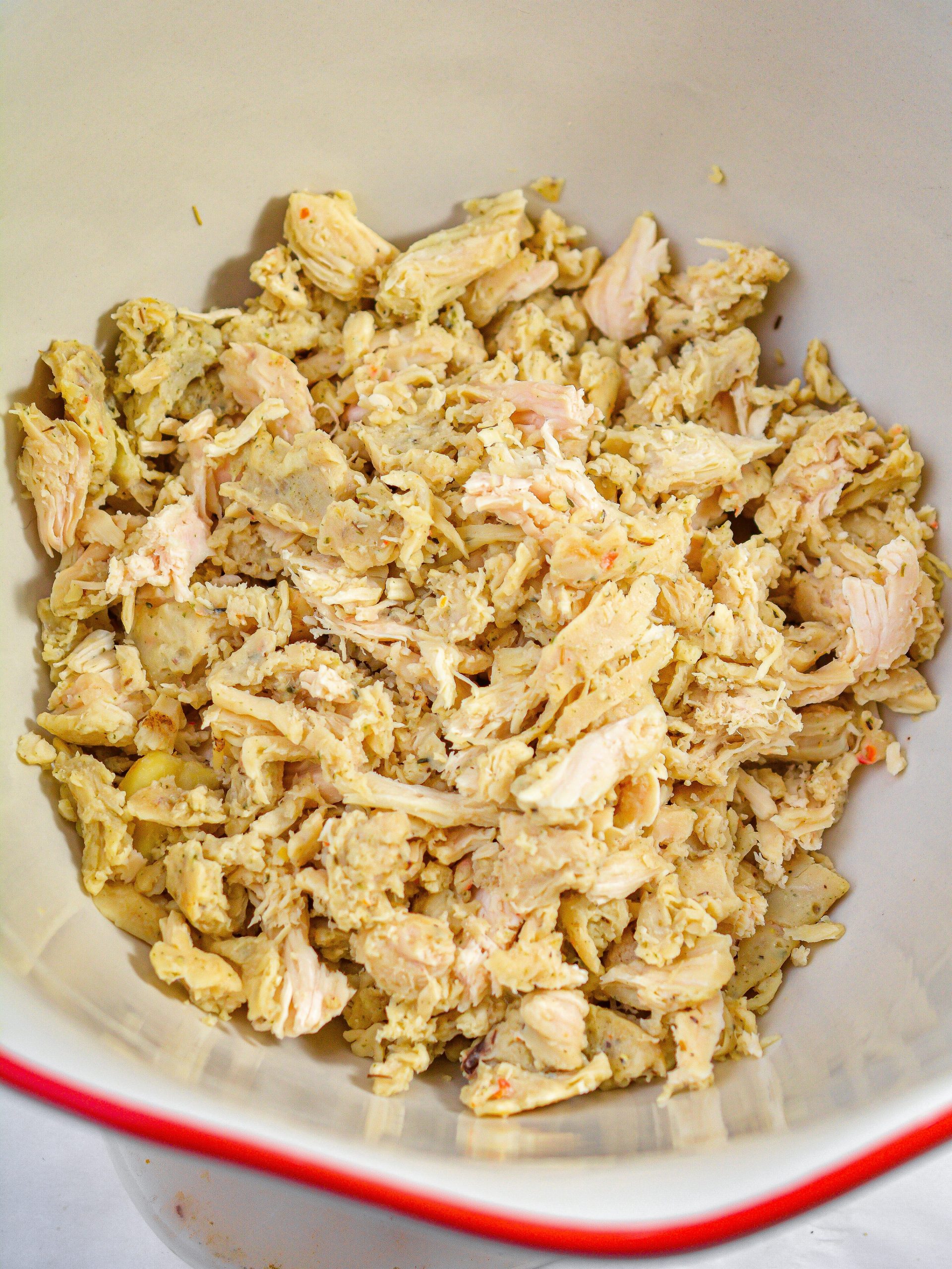 In a bowl, start by adding the shredded chicken and onion