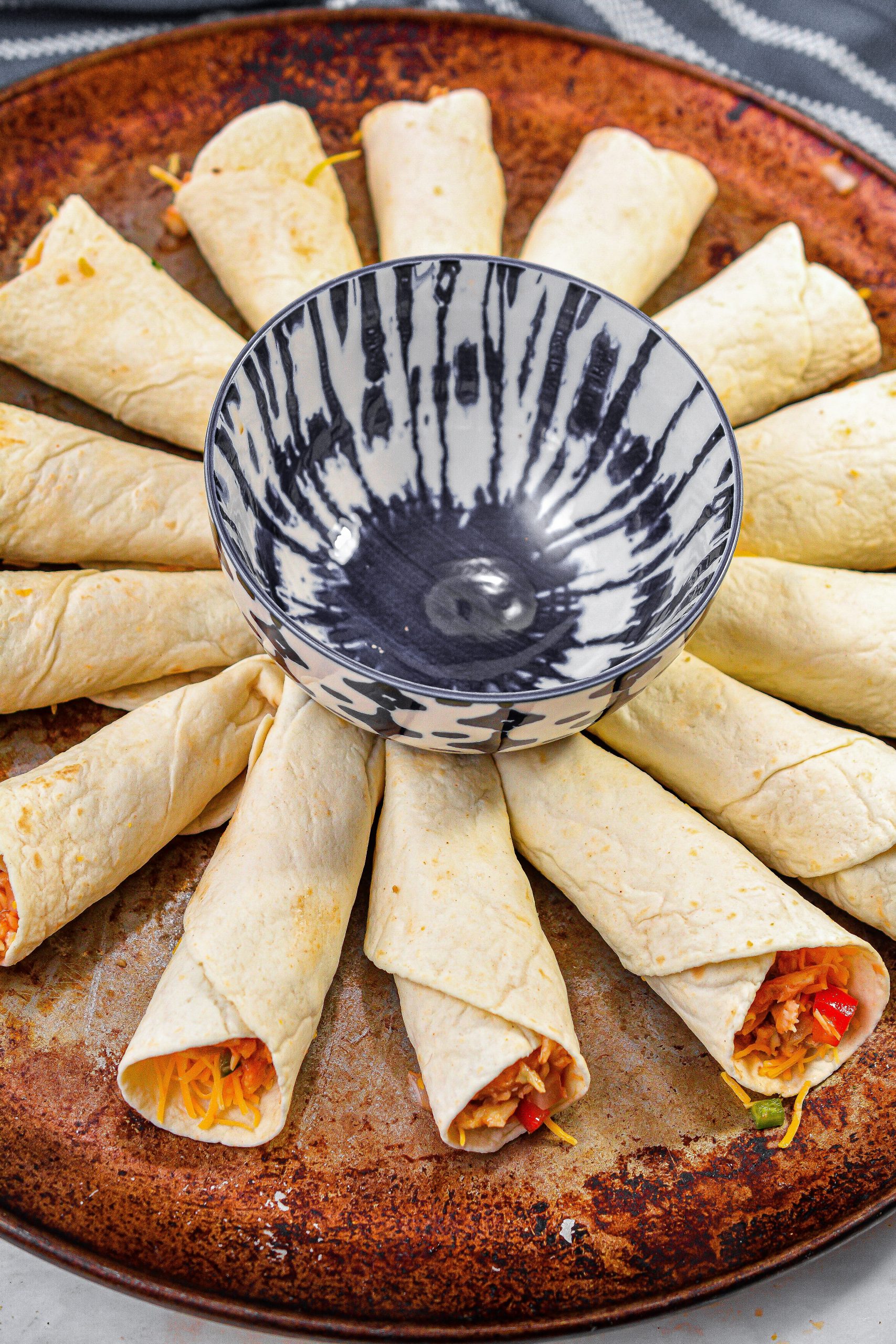 Place a bowl in the center of a round baking sheet, and layer the quesadilla cones in a circle around the bowl.