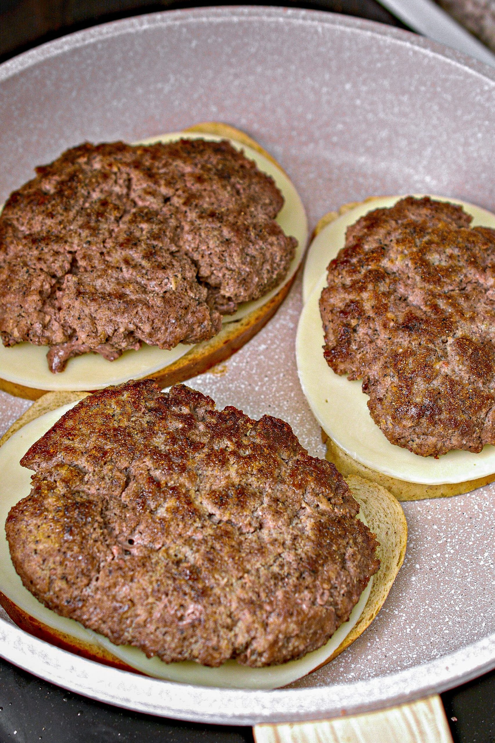 Top each slice of bread with 2 slices of provolone cheese, and a meat patty.