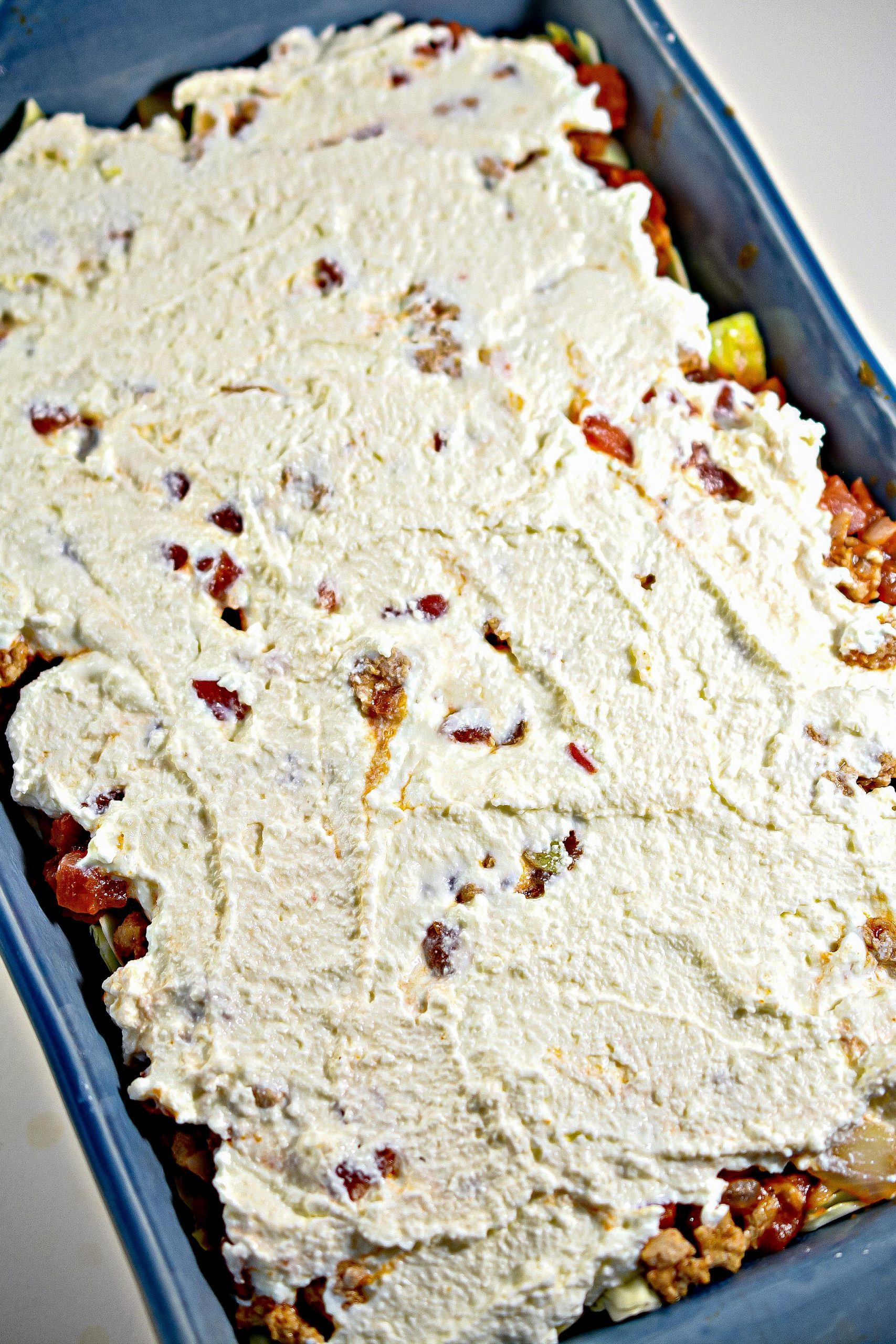 Place a layer of ricotta cheese over the casserole, 