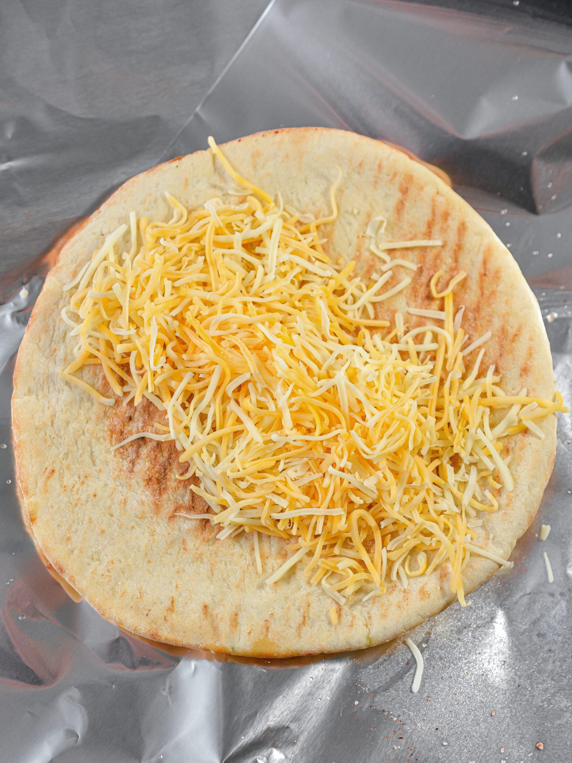  Place a layer of cheese down the center of each pita bread.