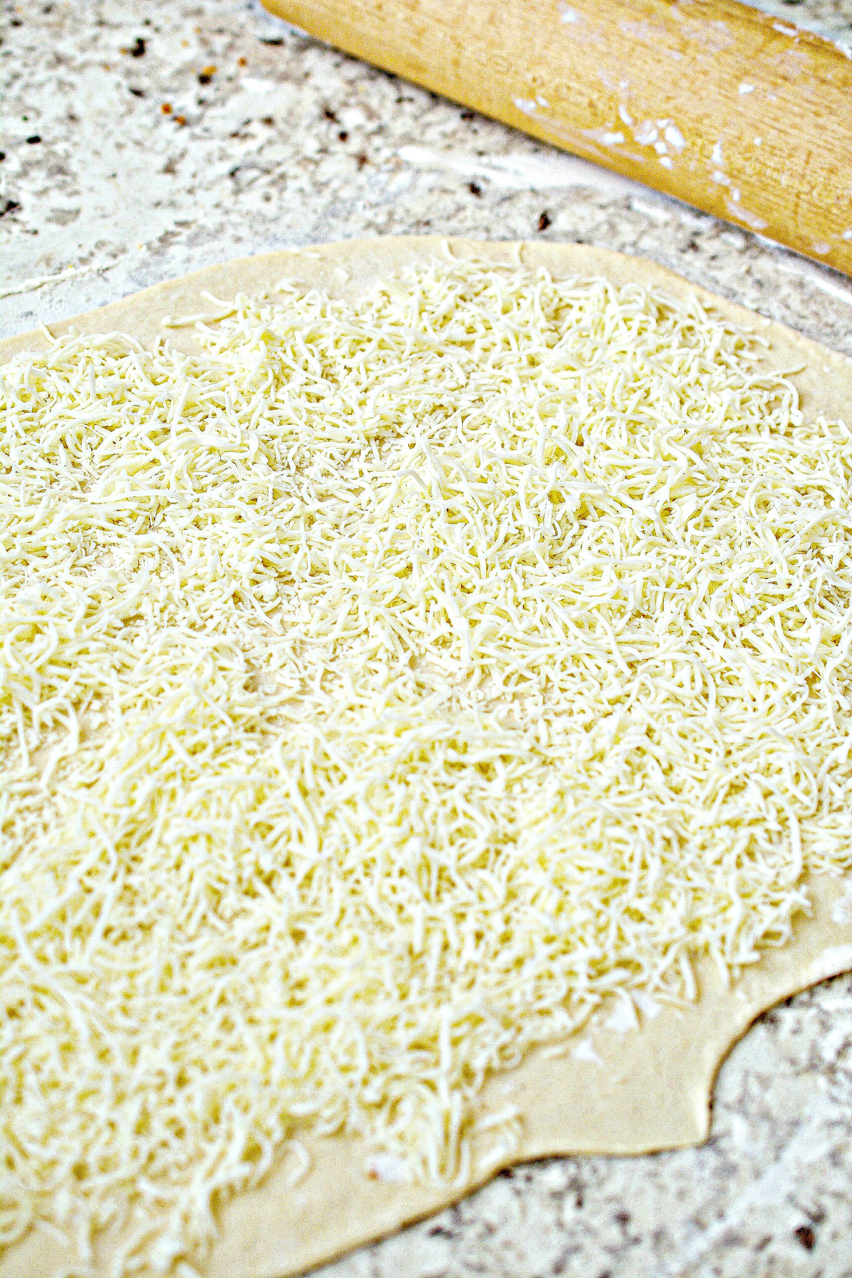 Sprinkle the mozzarella cheese on the dough.