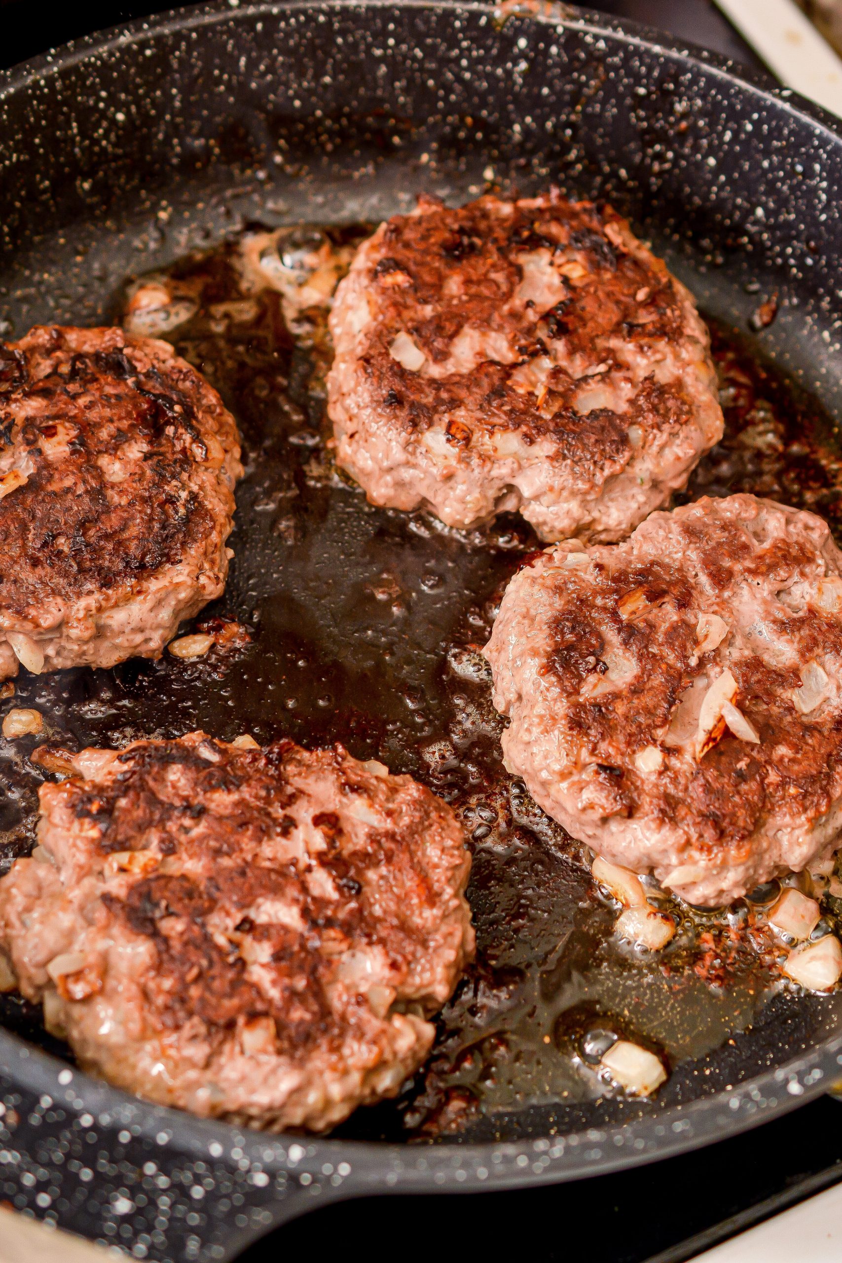 Form the meat into four even patties and place into the heated skillet. Saute until browned on both sides and cooked through. Remove the patties from the skillet and place them on the side for later.