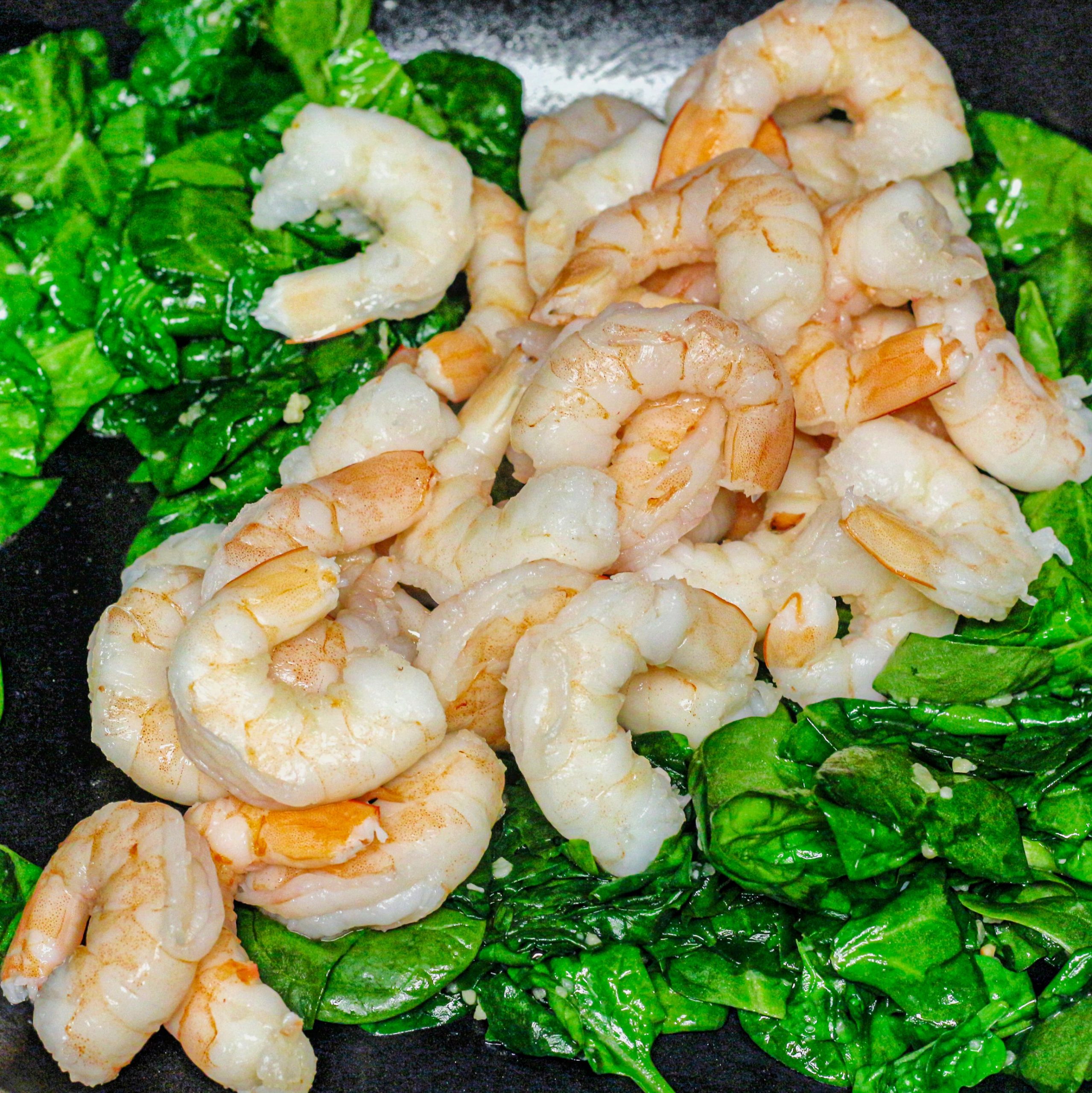 Add the cooked shrimp to the spinach and toss to combine.