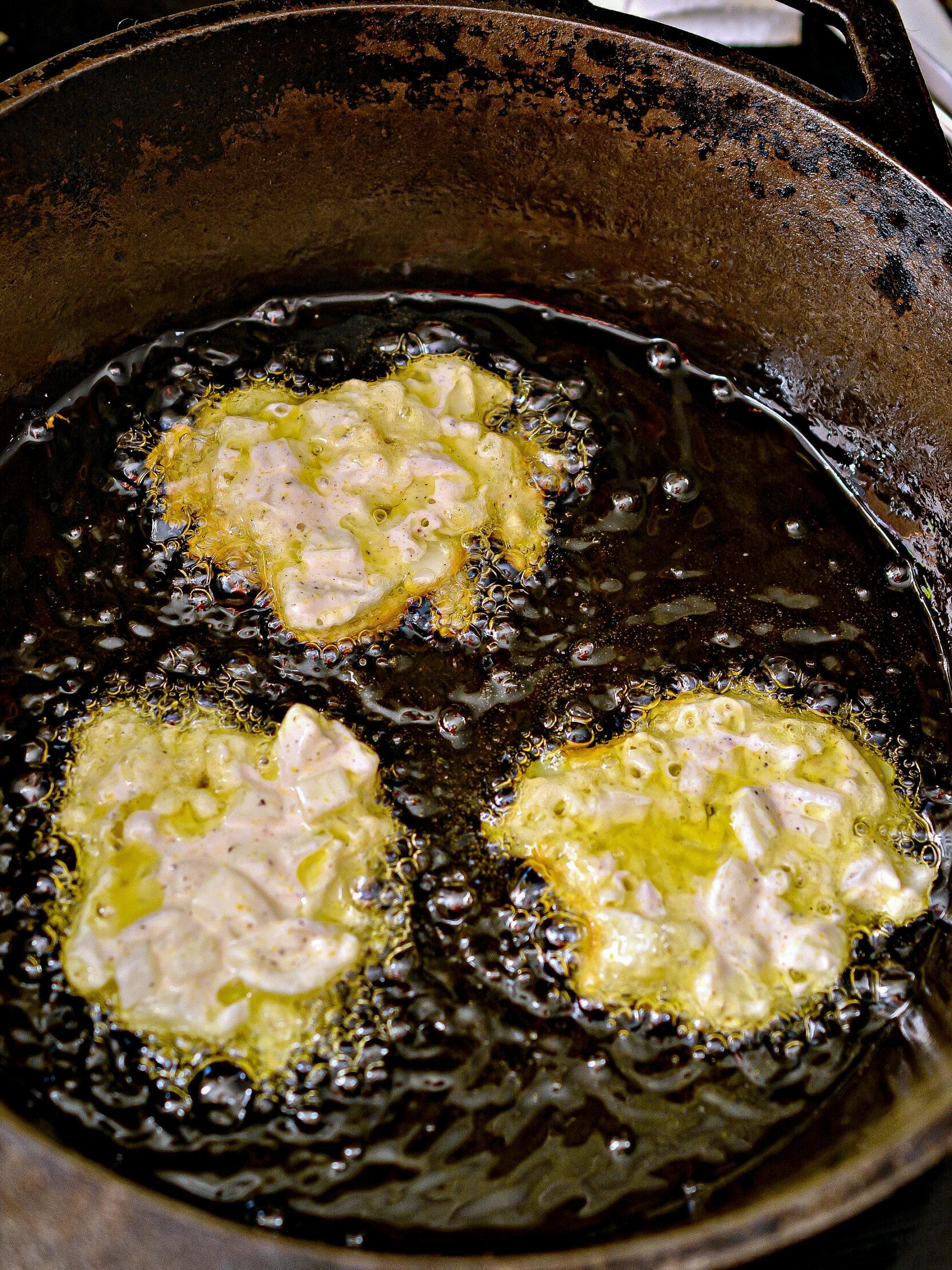 When the oil has reached a temperature of at least 175 degrees, drop the batter into the skillet by the tablespoon, spreading it out a bit as you go.