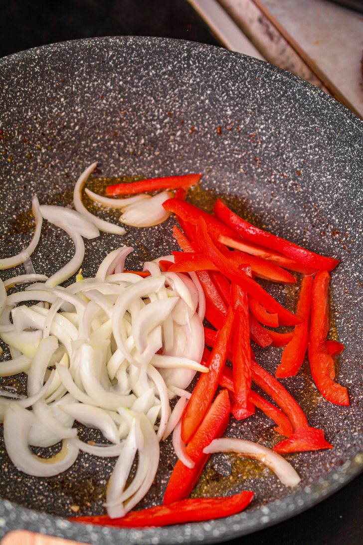 Reduce the heat to medium on the stove, and add some more olive oil to the skillet along with the onions and peppers.