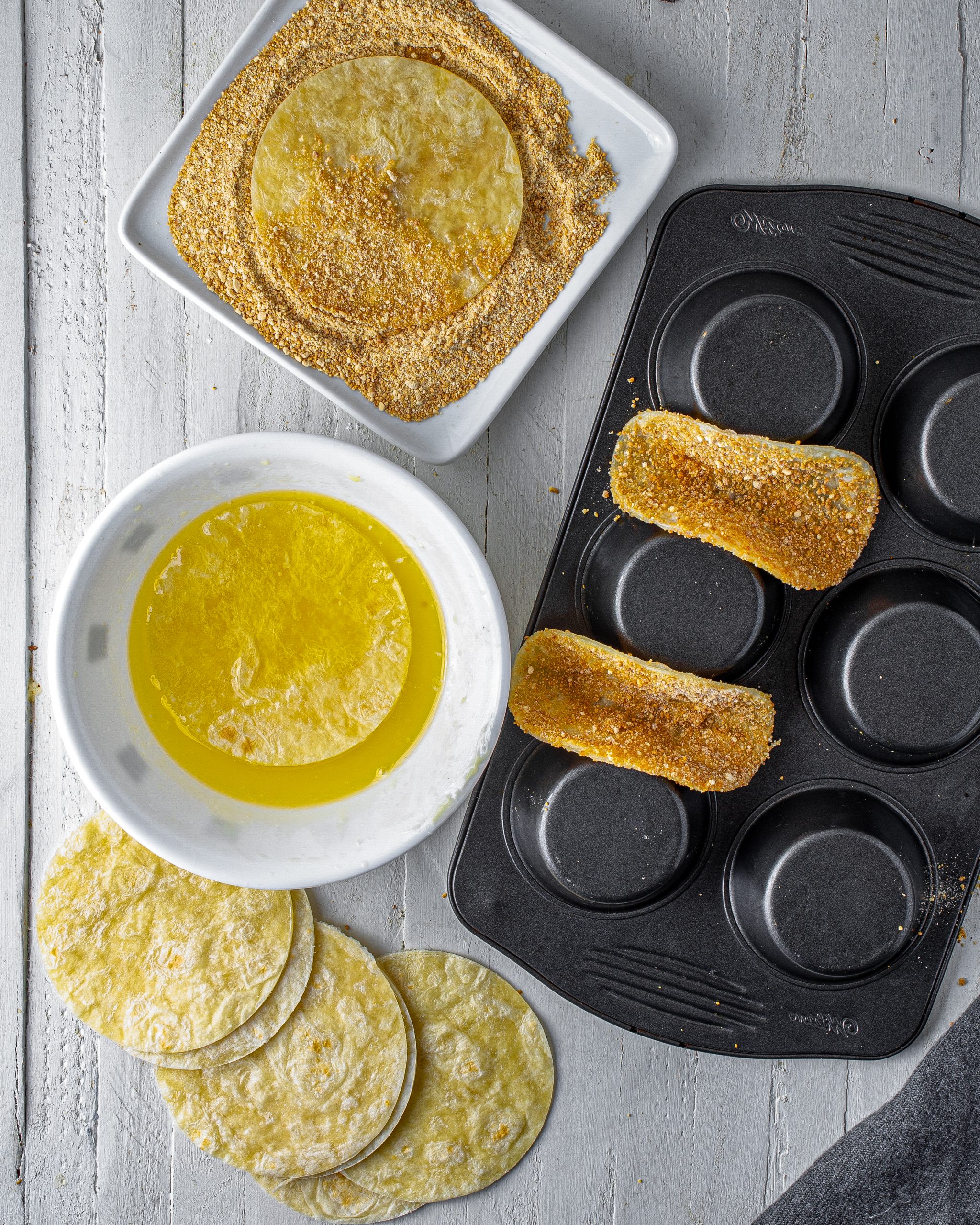 Fold the tortillas into a taco shape, and place them in between the cups of the upside-down muffin tin. 