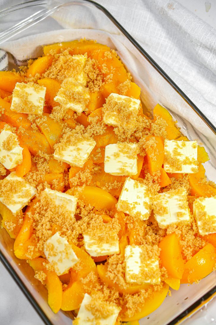 Scatter the butter pieces over the peaches and sprinkle the brown sugar over them.