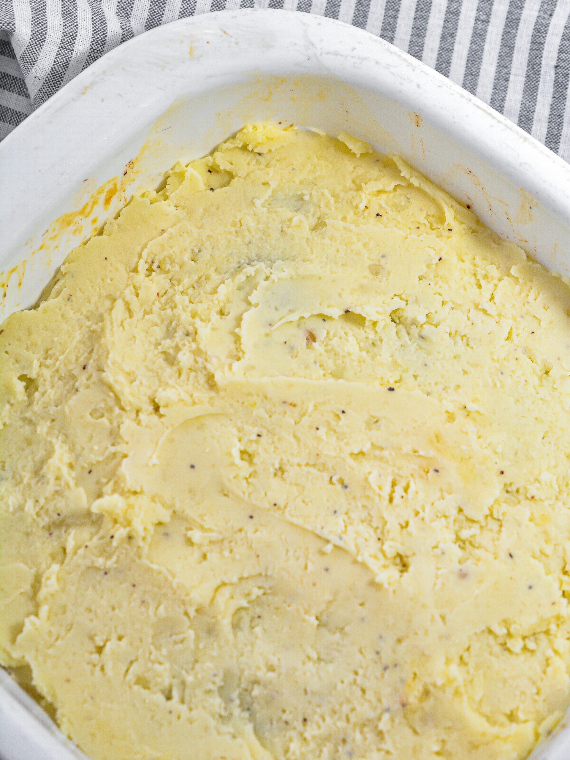 Spread the cooked potatoes over the meatloaf mixture in the baking dish.