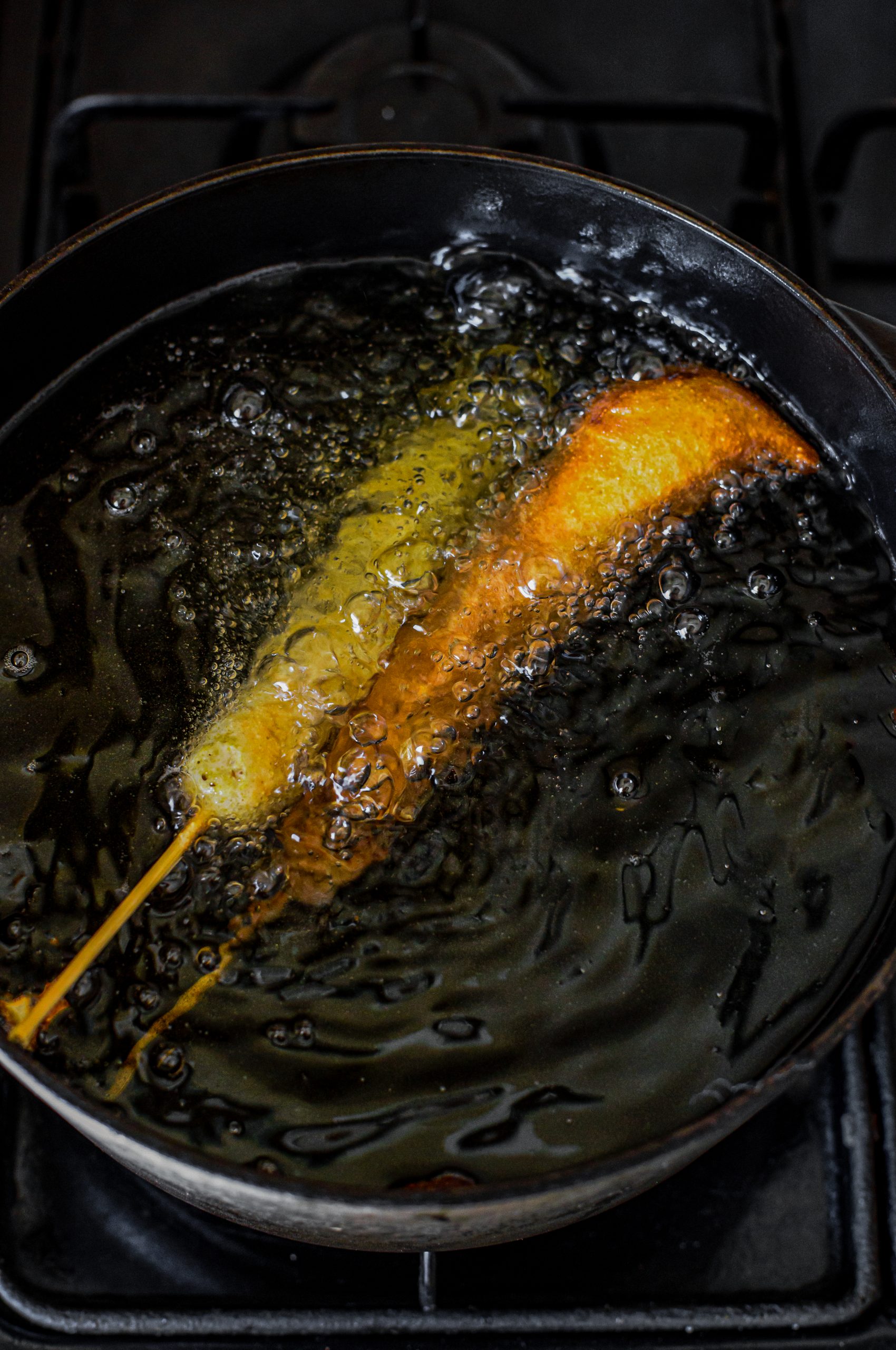 Place the battered corn dogs into the heated oil, and cook for 2-3 minutes until golden brown. 