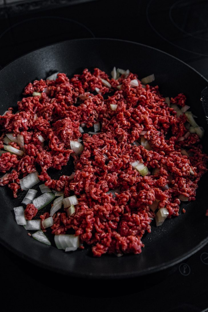 Add the ground beef and diced onion in a large skillet over medium heat.
