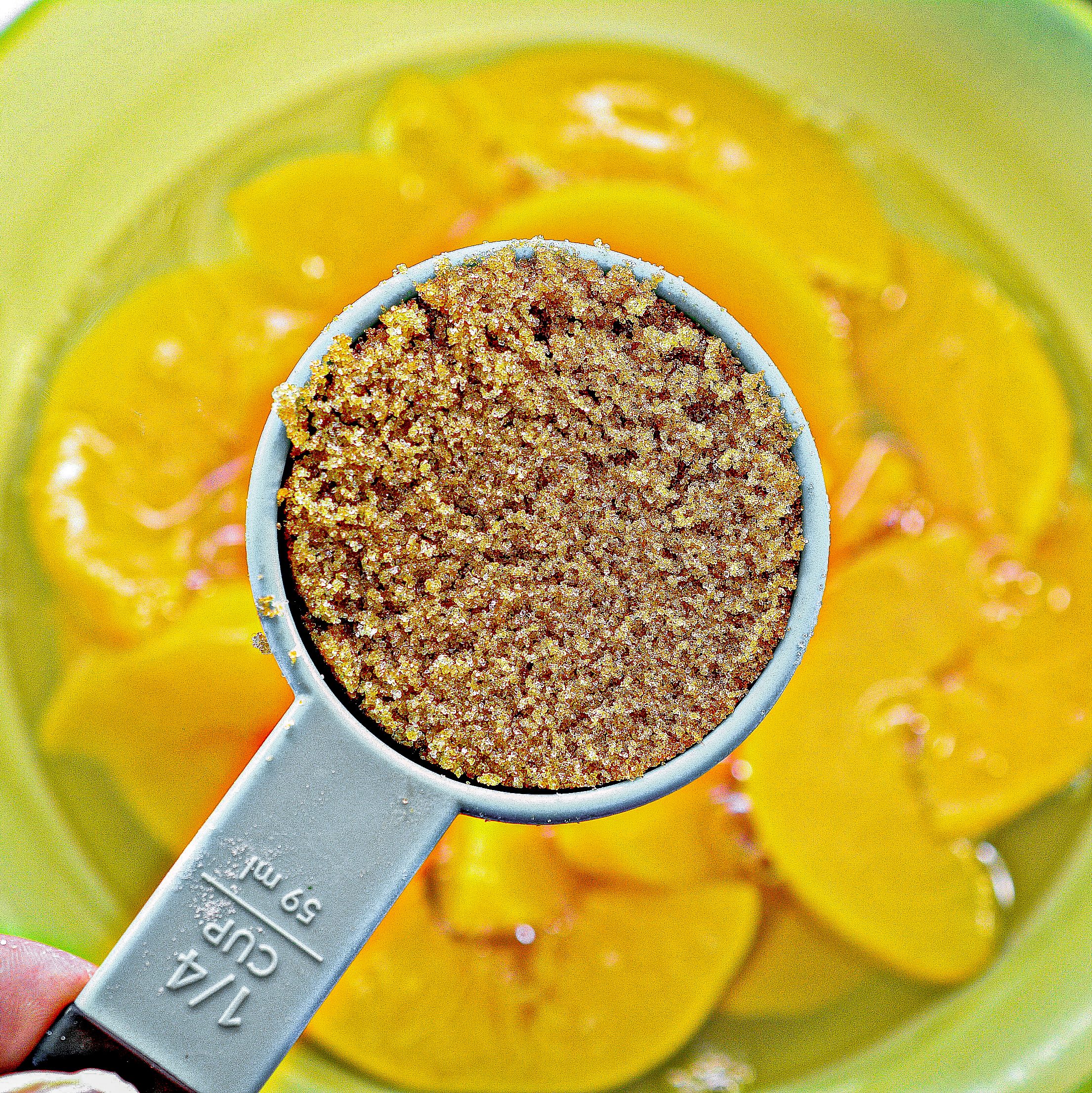 Add canned peaches and brown sugar into a bowl.