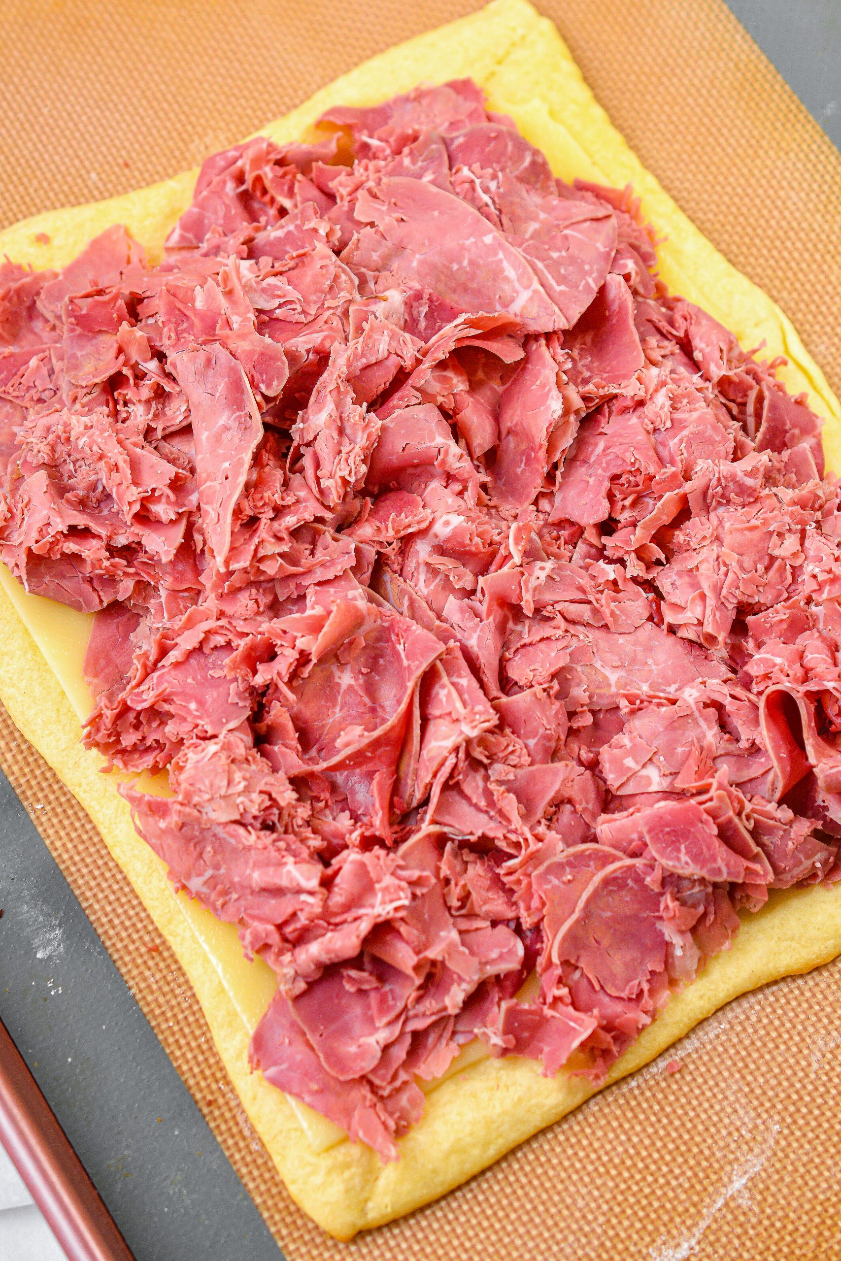 Step 7. Place the corned beef on top of the swiss cheese.