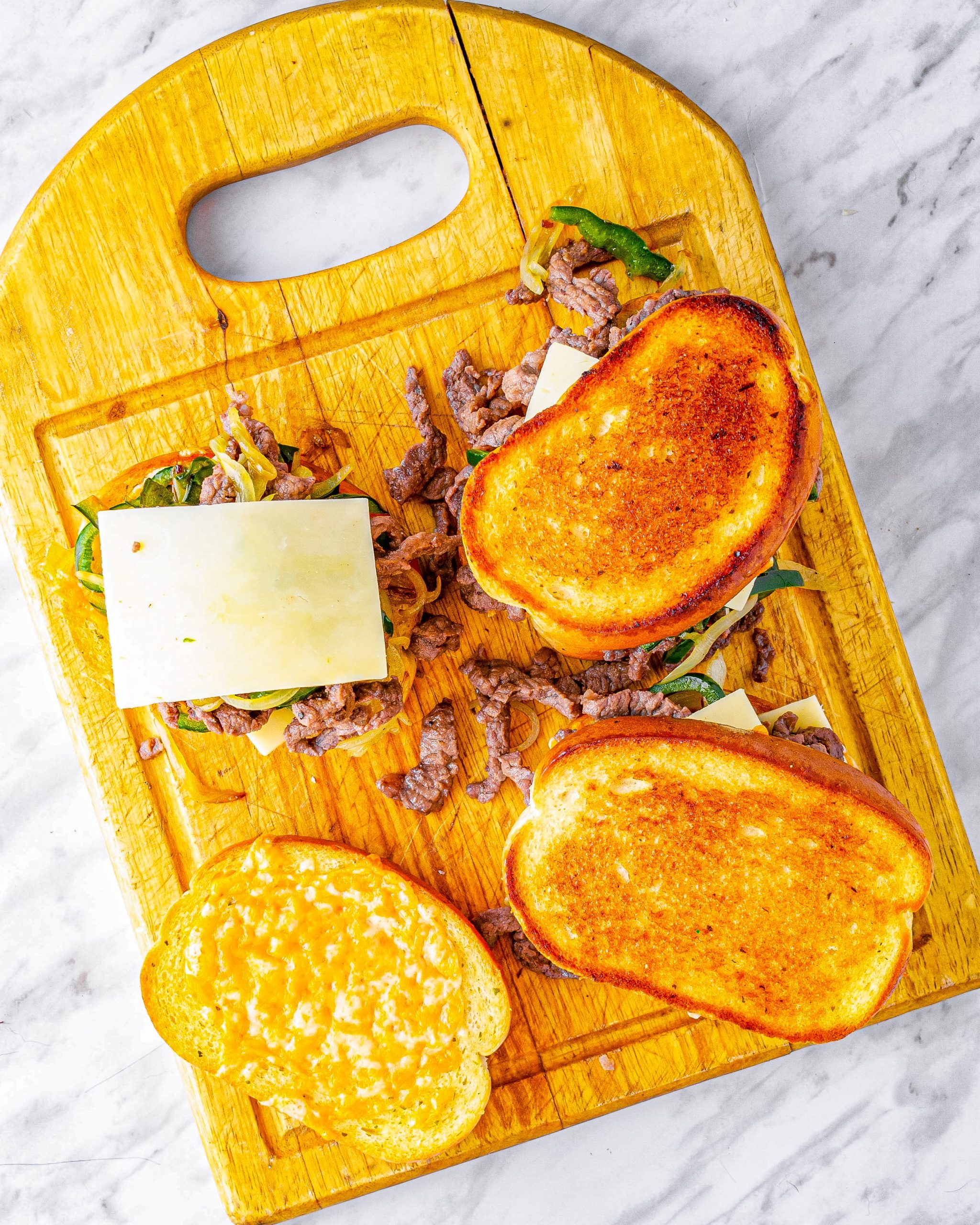 Top each sandwich with a slice of mozzarella cheese and another slice of garlic cheese toast on top.