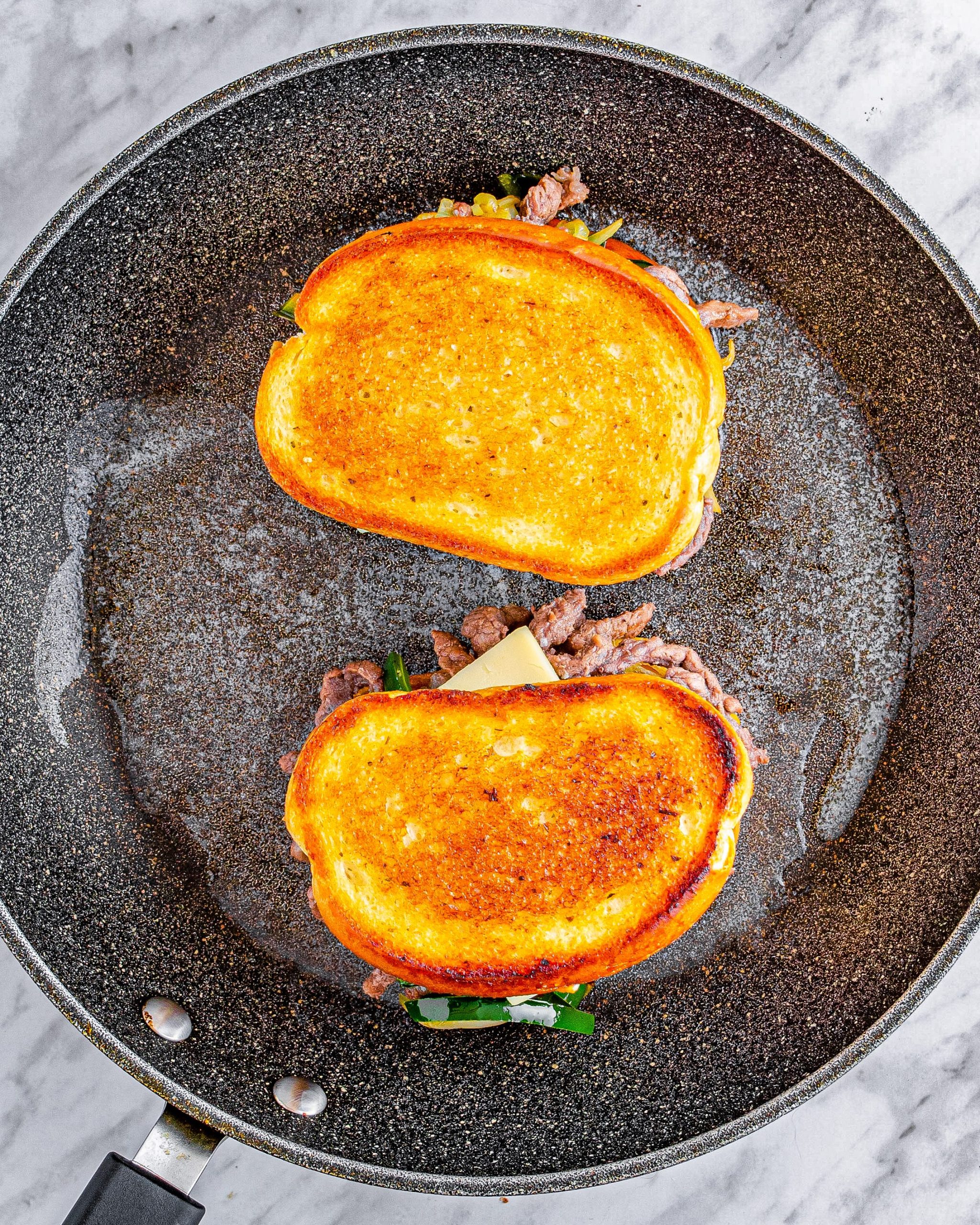 Place the sandwiches into the skillet, cooking for several minutes on top until the bread is toasted and the cheese has melted.