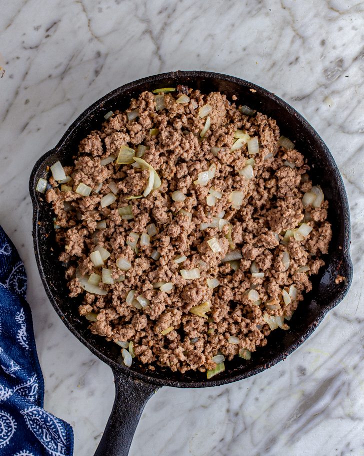 Place the ground beef into a skillet over medium-high heat, and saute until browned completely. Drain any excess grease. 