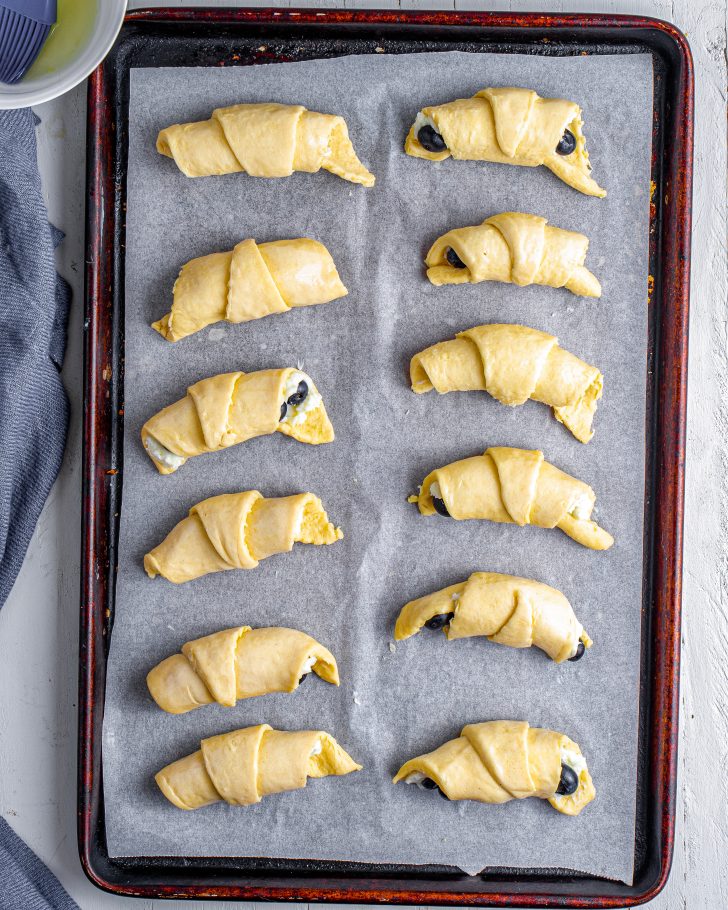 Brush the filled crescent rolls with egg white. 