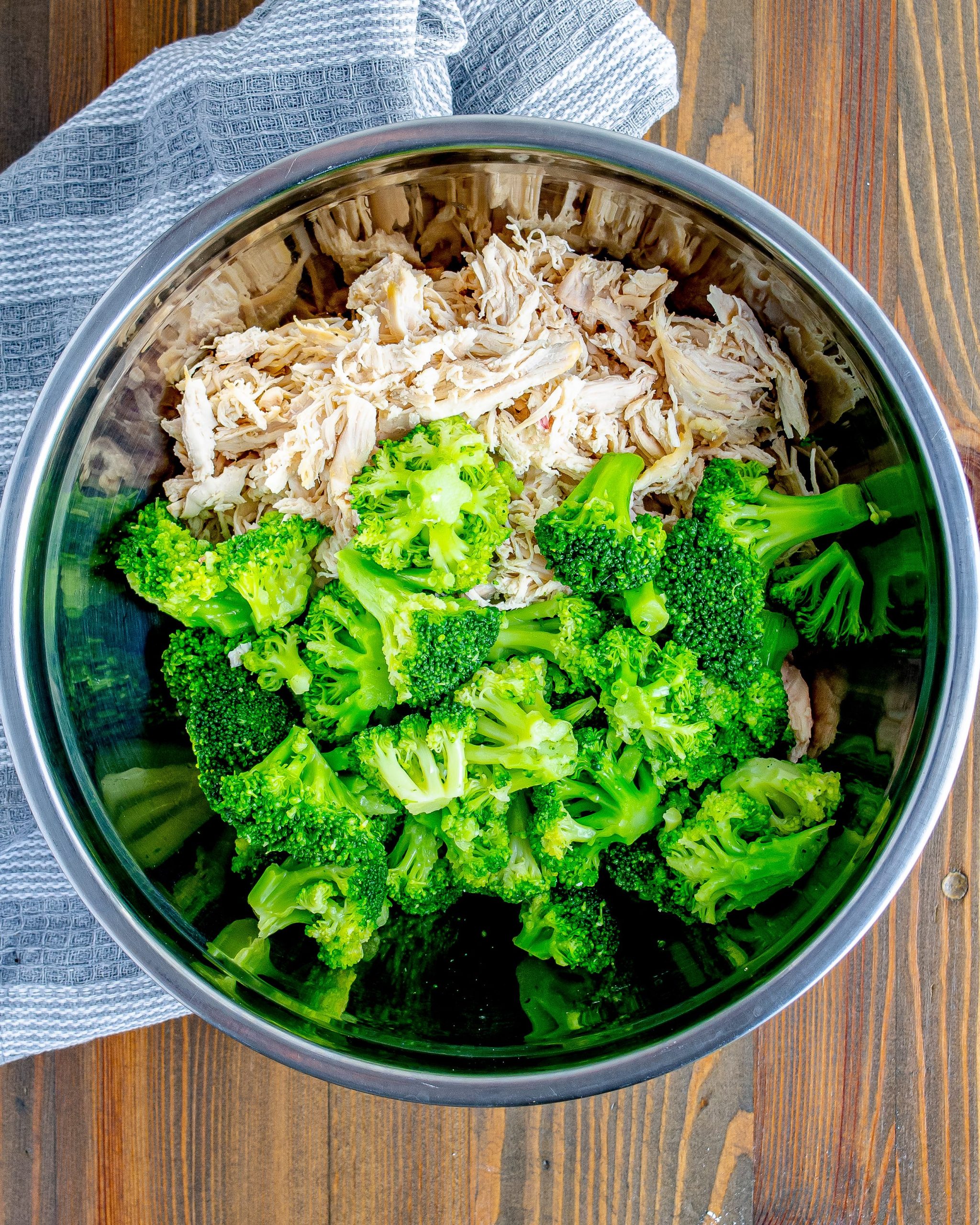 In a large mixing bowl, combine the shredded chicken and cooked broccoli.