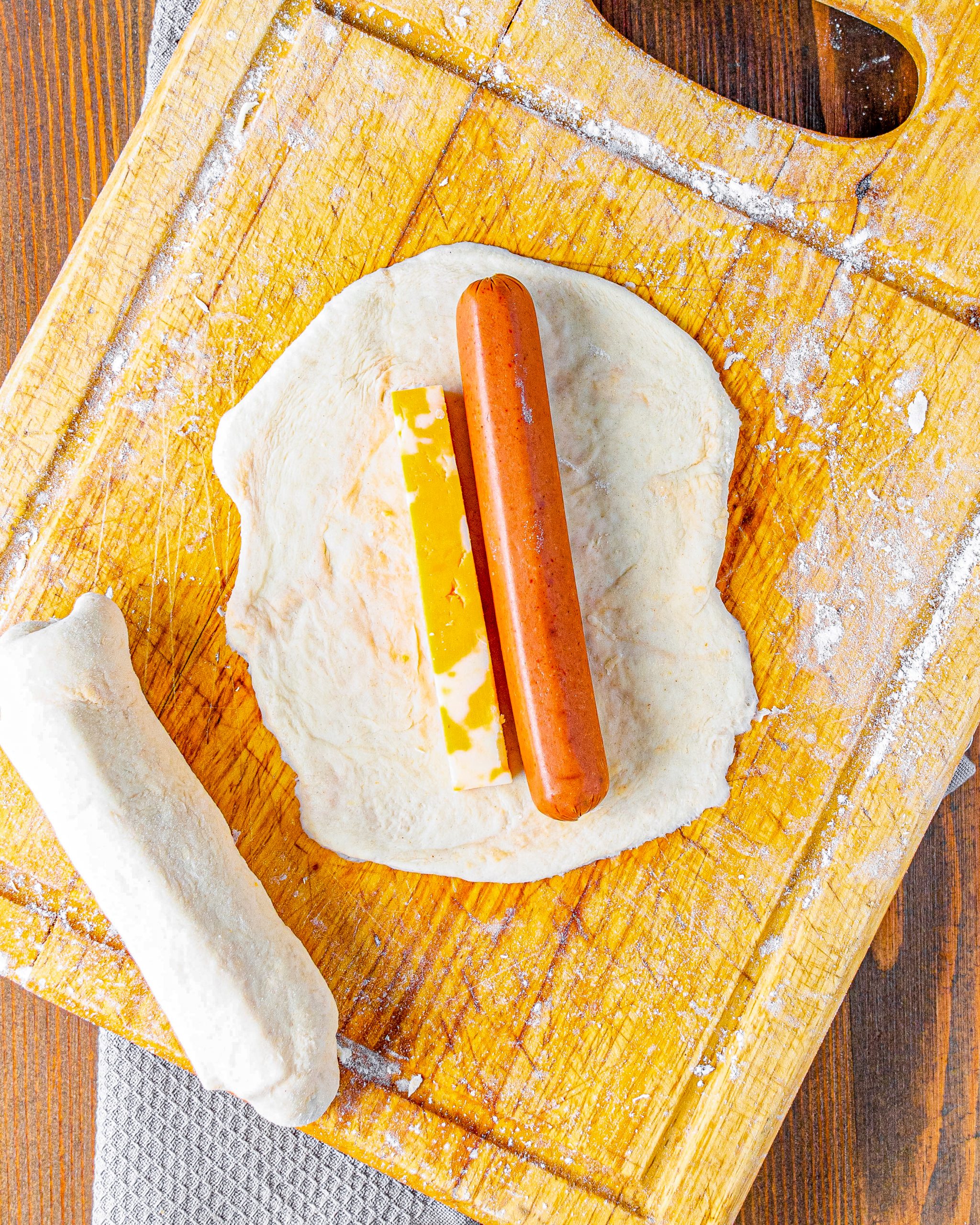 Add a hotdog and cheese stick to the center of each rectangle of dough. 