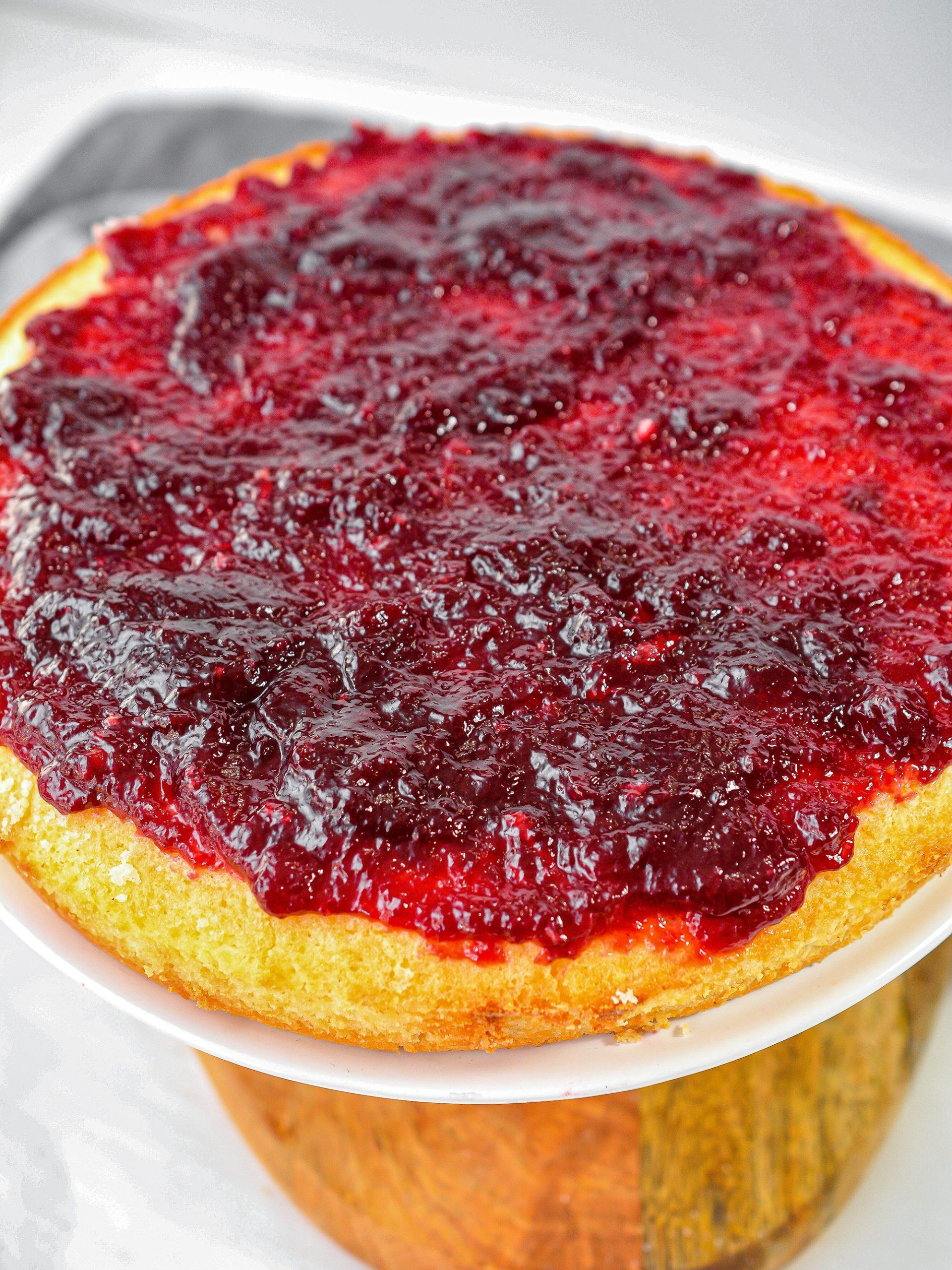 Top the layer of cake with a layer of raspberry preserves.