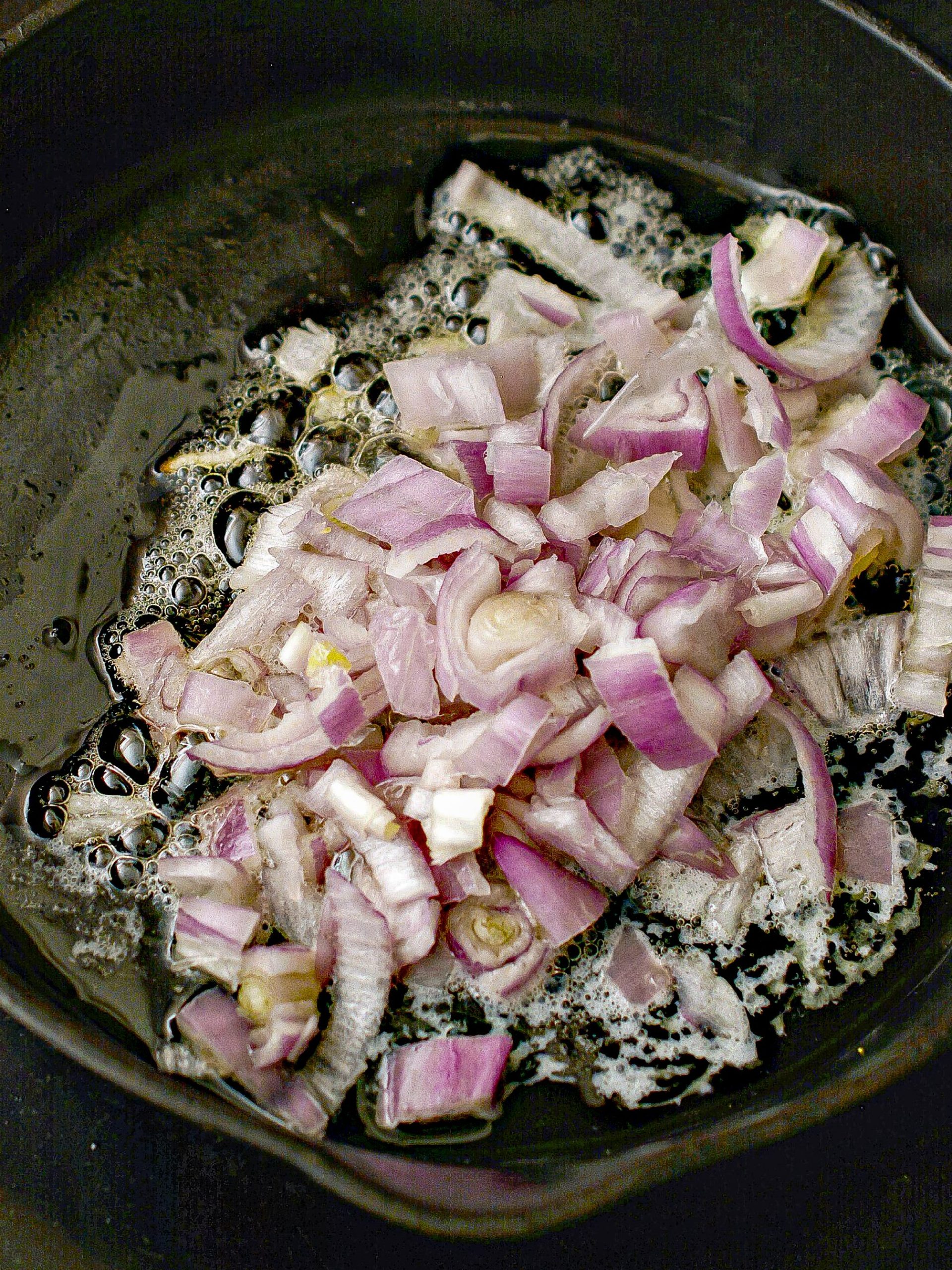 Place the shallots into the skillet and cook until they begin to soften and brown.