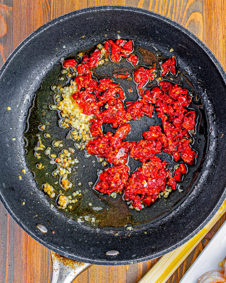 Lower the heat in the skillet to medium, and add the sun-dried tomatoes and garlic. 