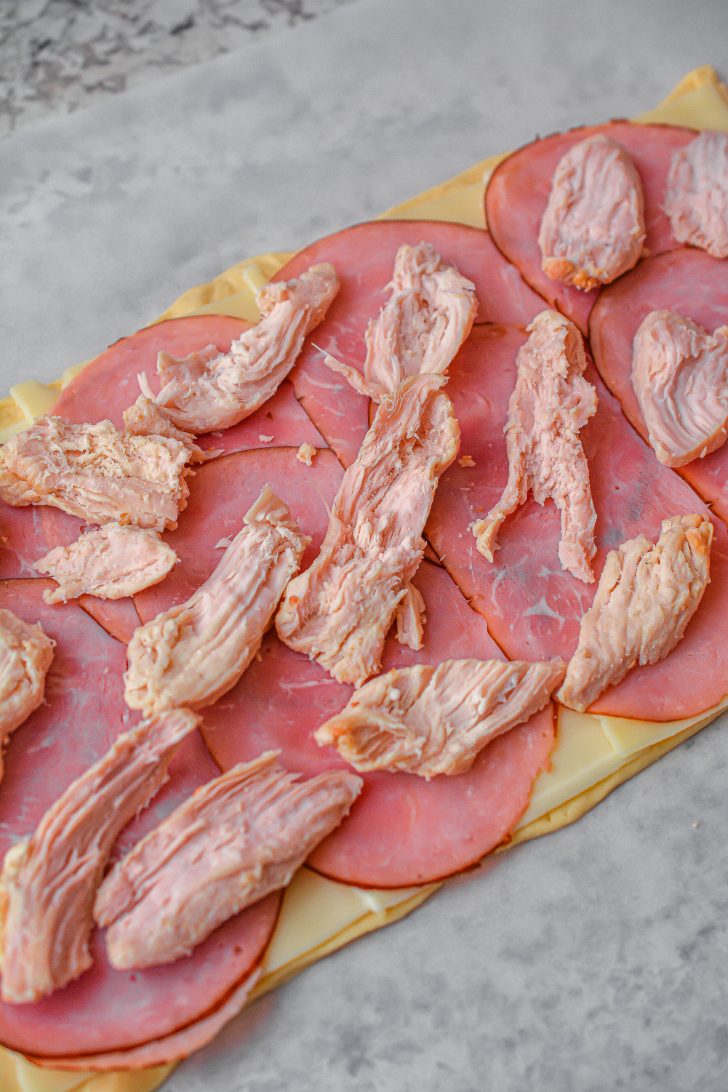 Spread the chicken pieces over the top of the ham slices.