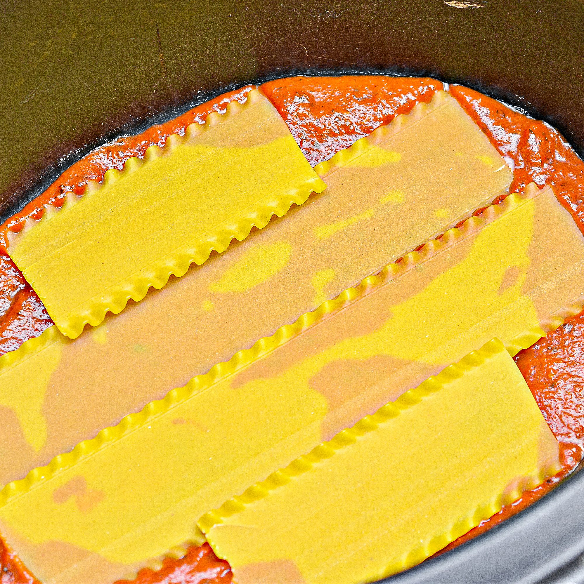 Place a thin layer of pasta sauce in the bottom of the crockpot, and layer 3-4 lasagna noodles on top of it.
