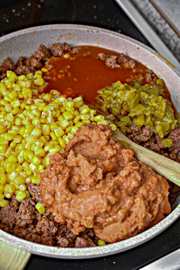 add 1 can of mild enchilada sauce, 1 can of refried beans, and  1 small can of green chilis.