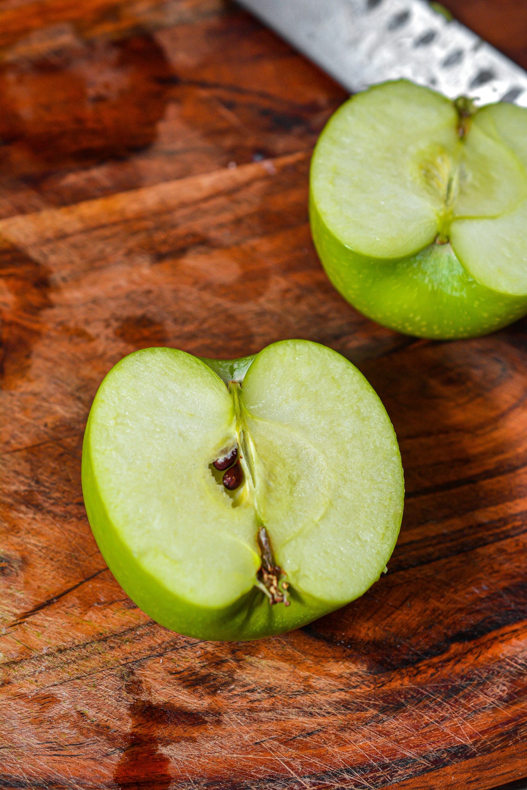 Cut each apple in half lengthwise. Use a spoon to core the apple and scoop out a hole in the middle of it.