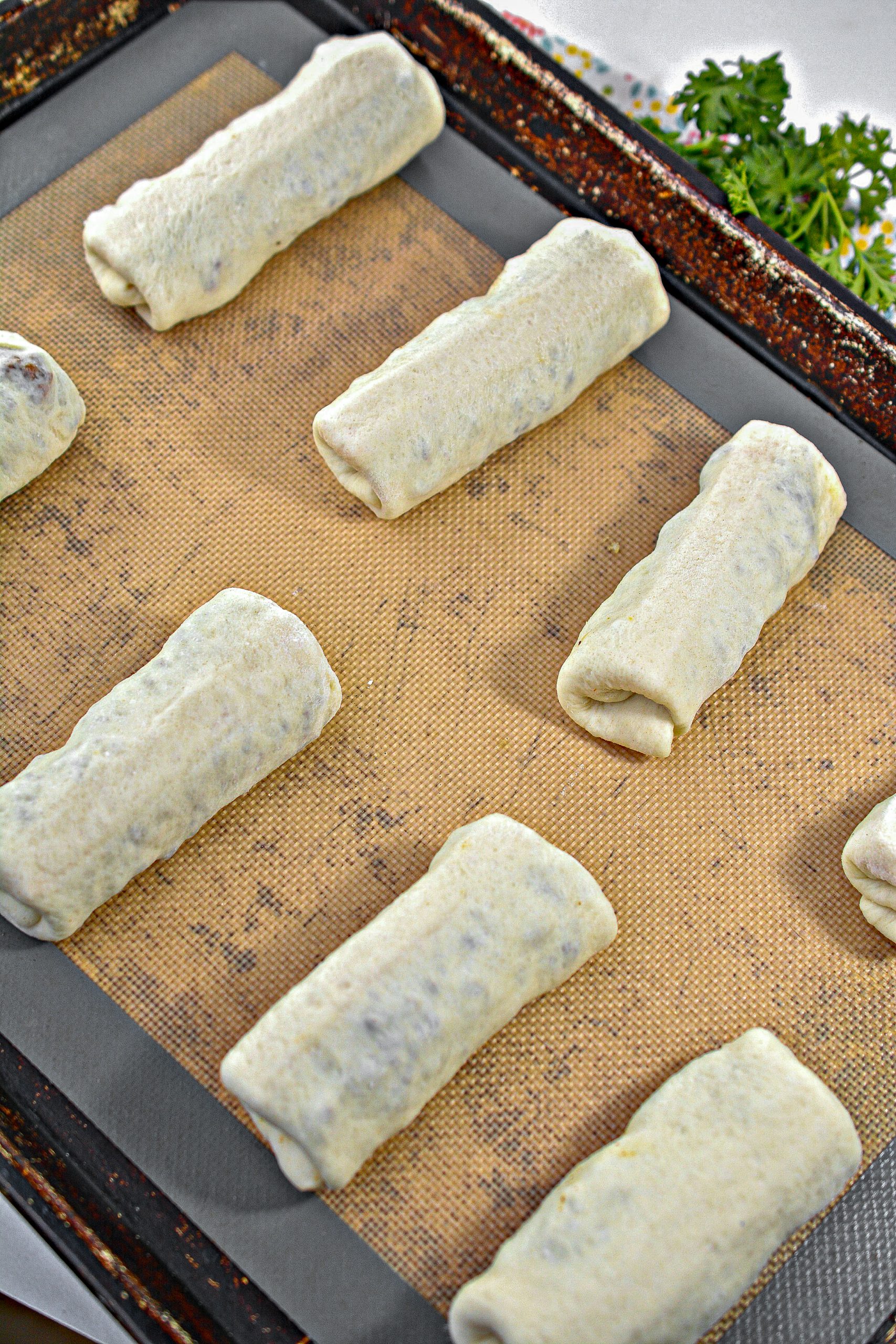 Carefully fold in the ends of each rectangle of dough, and then roll them into breadsticks over the filling.
