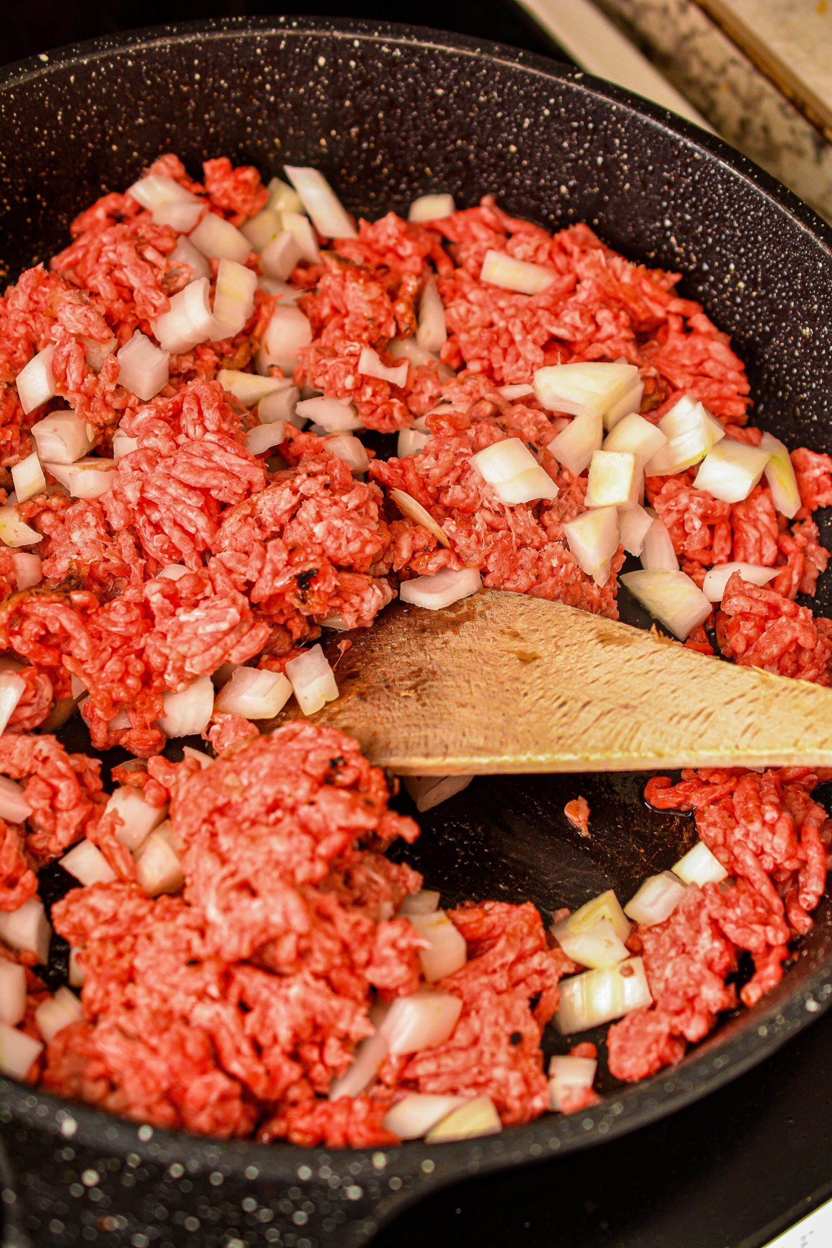 Heat the ground beef and onion in a skillet over medium-high heat until the meat is browned and the onion has softened. Drain any excess fat.