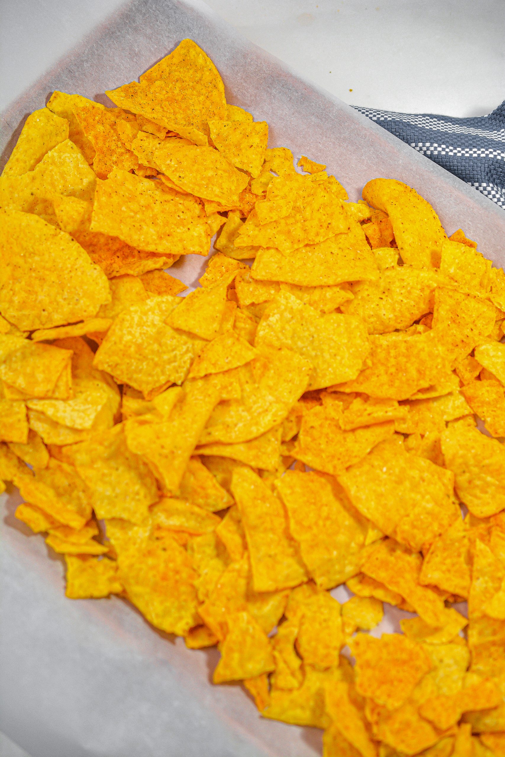 Place one bag of tortilla chips on each of two different baking sheets. 