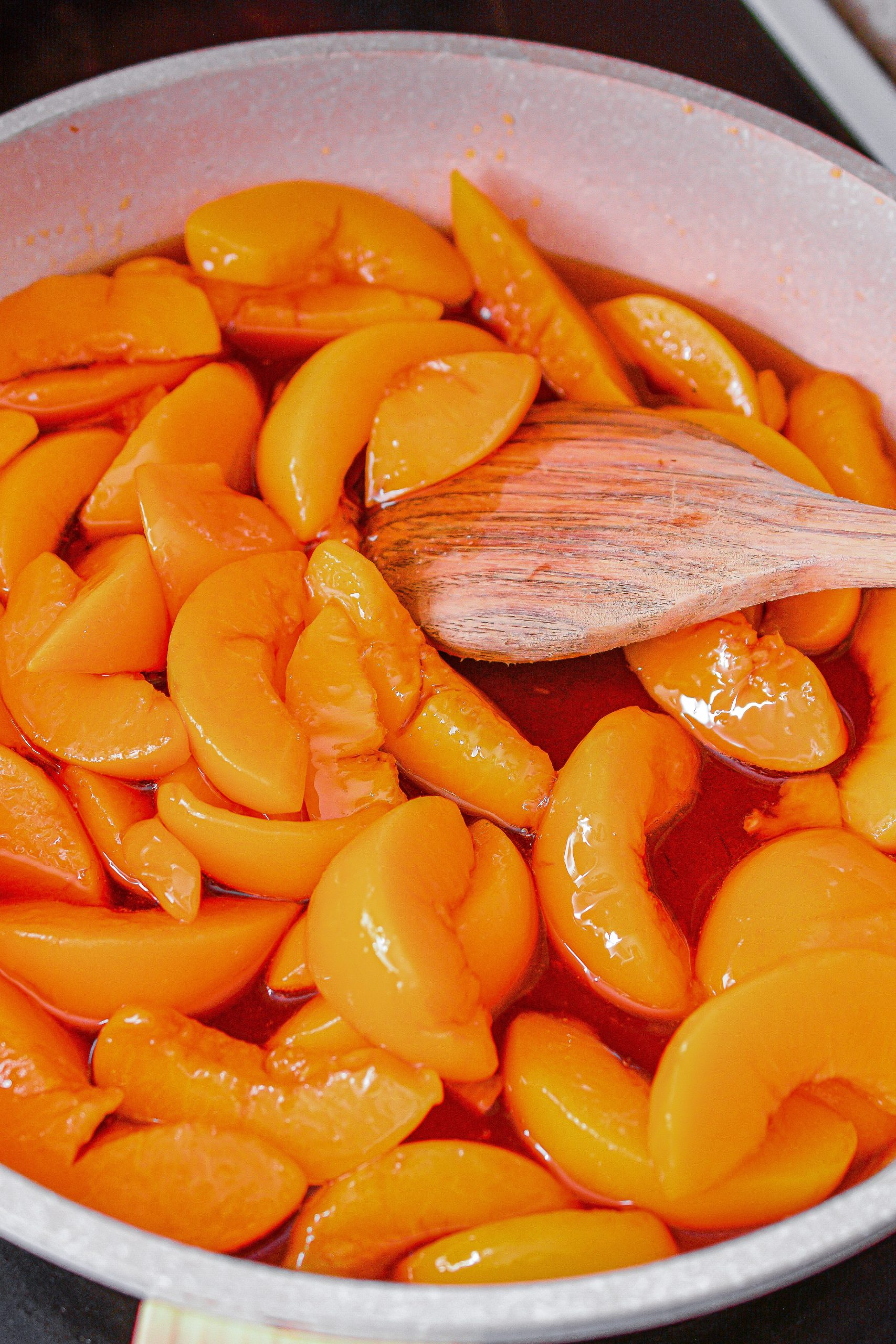 Place the peaches in a skillet over medium heat on the stove.