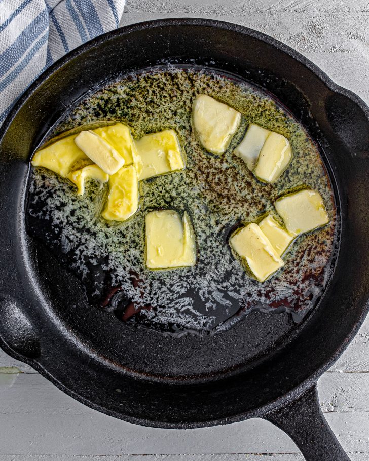 Place the butter into an oven safe skillet on the stove, and melt it over medium heat.