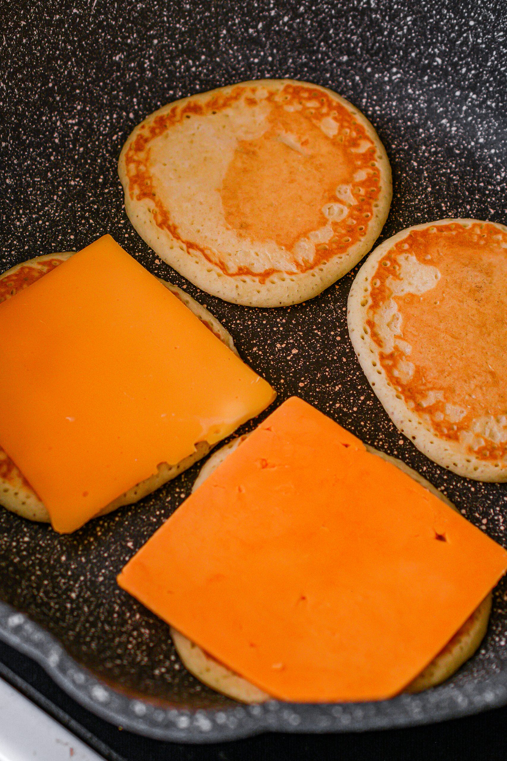 Top four of the pancakes with a slice of American cheese.