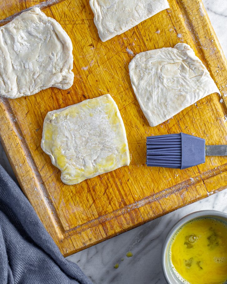 Brush the squares of puff pastry lightly with the egg. 