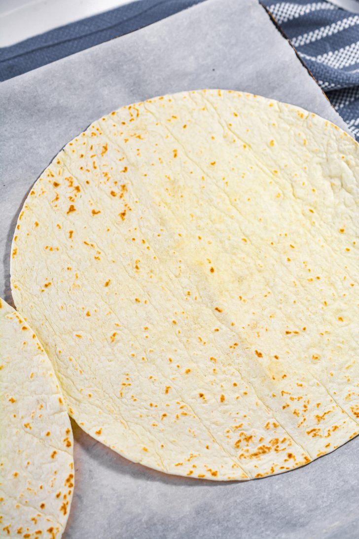 Lay two large flour tortillas on a lined baking sheet.