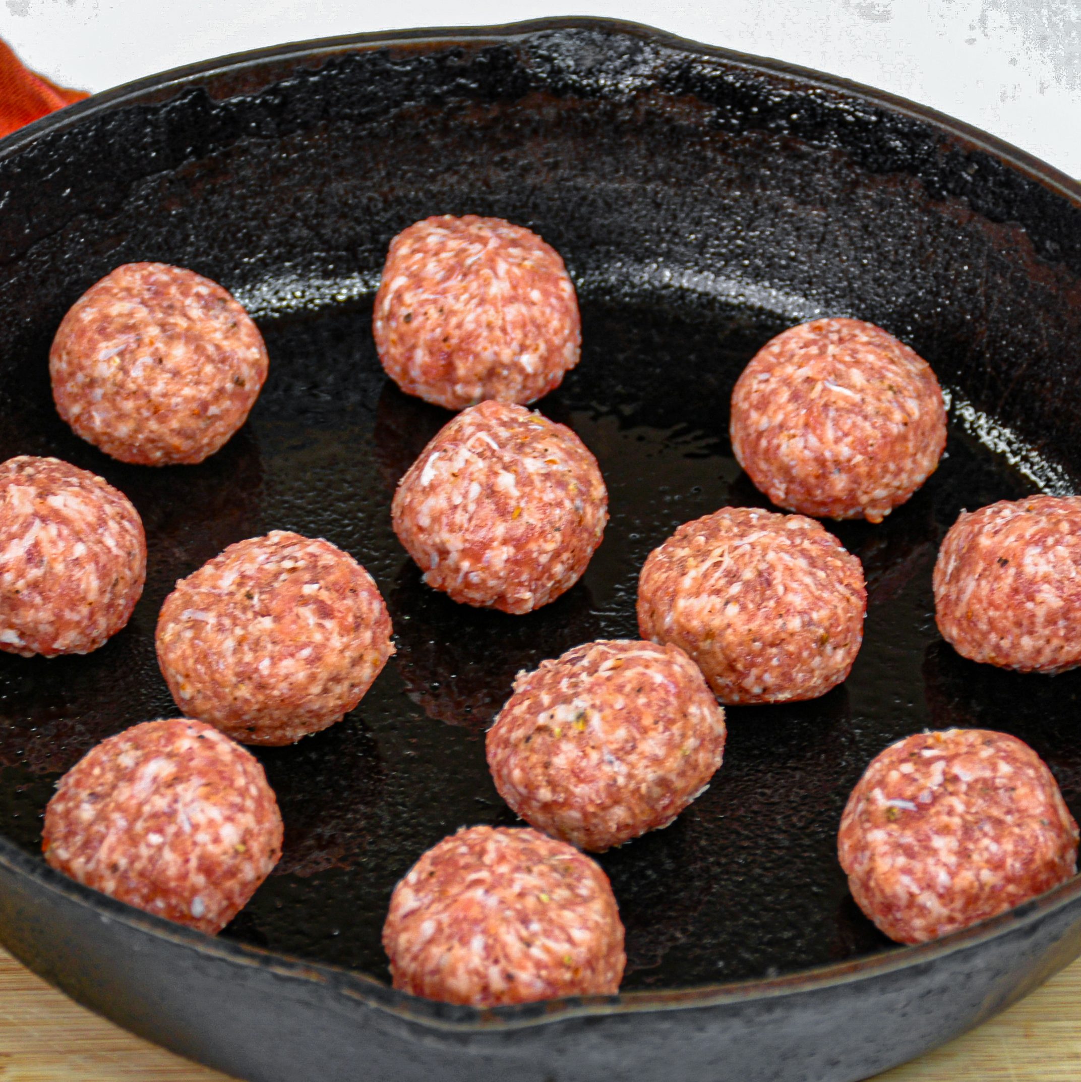 Add one meatball at a time to the heated skillet.