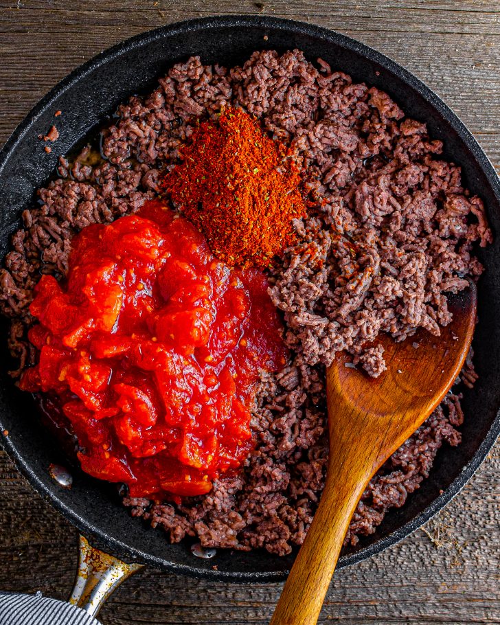 Once ground beef is cooked, stir in the taco seasoning and tomatoes.