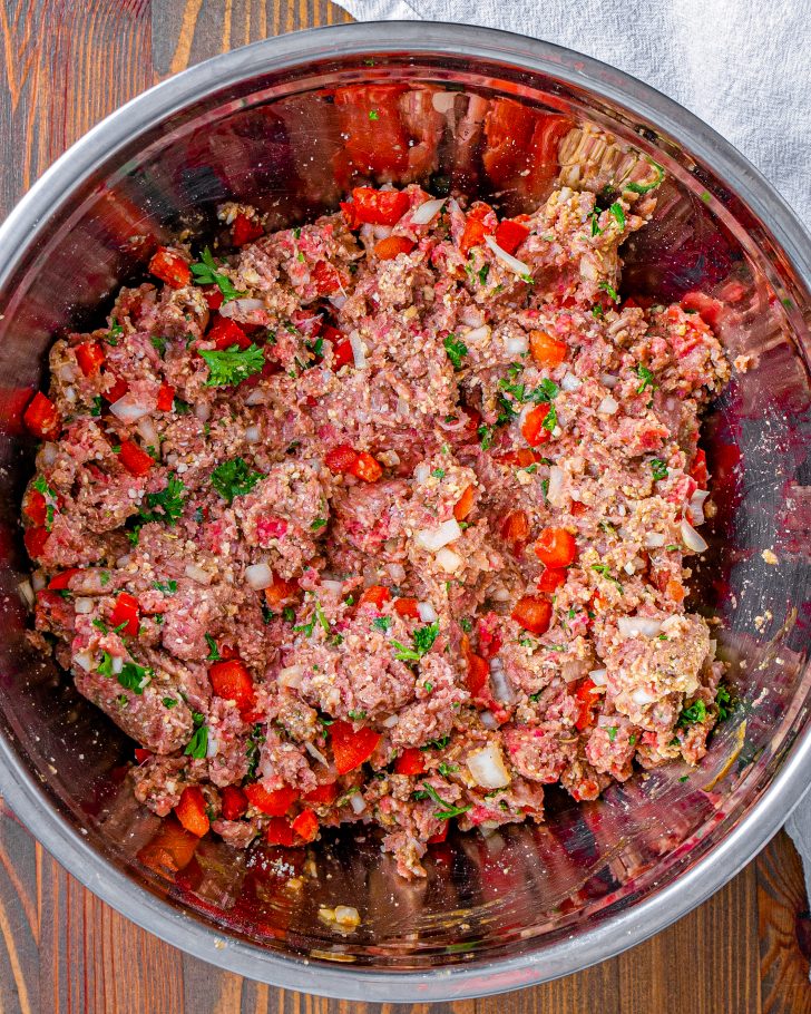 Add the ingredients for the meatloaf into a mixing bowl, and knead with your hands until well combined.