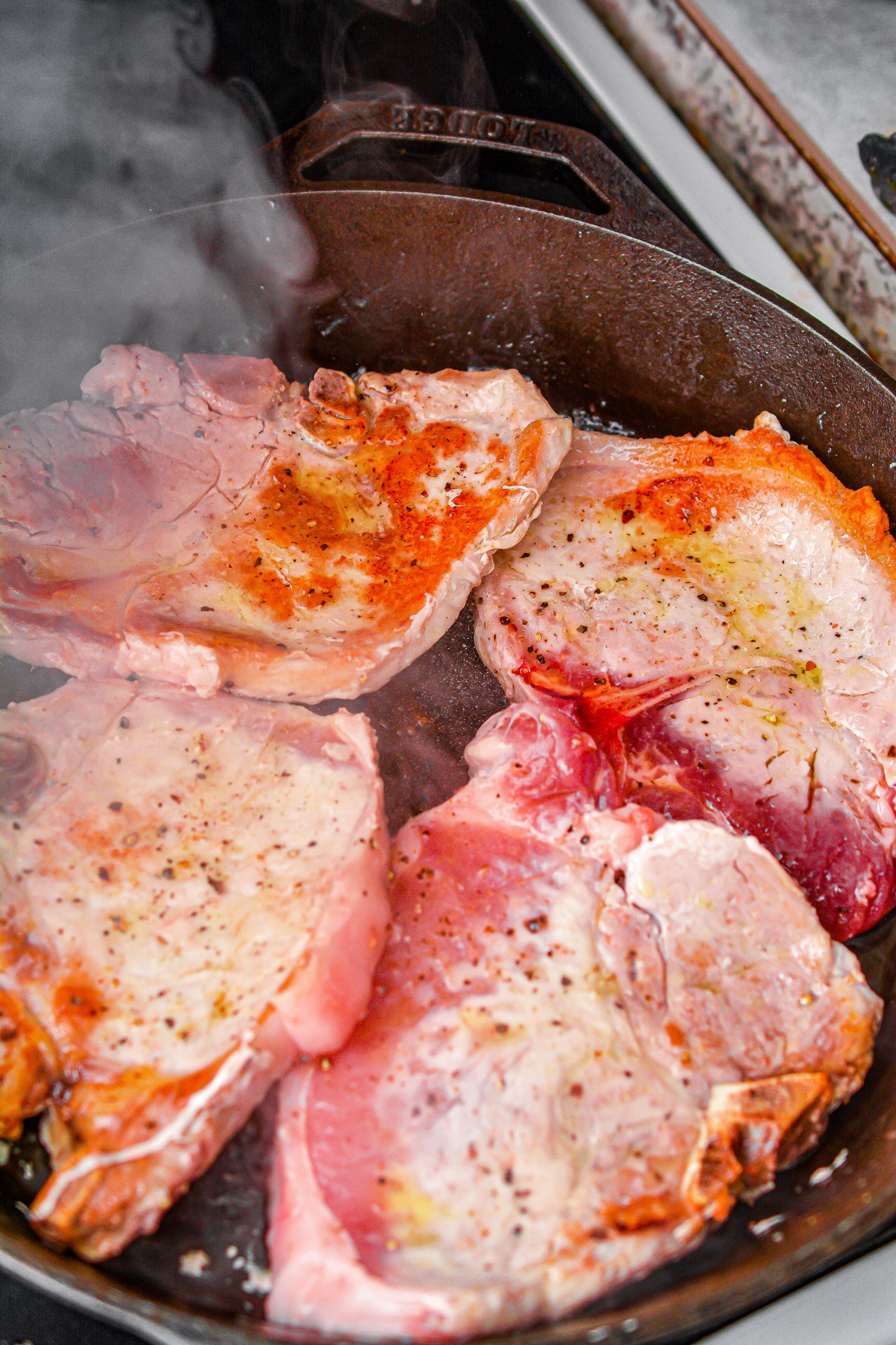 Heat the oil in a skillet over medium-high heat and sear both sides of the pork chops. Remove and set aside.