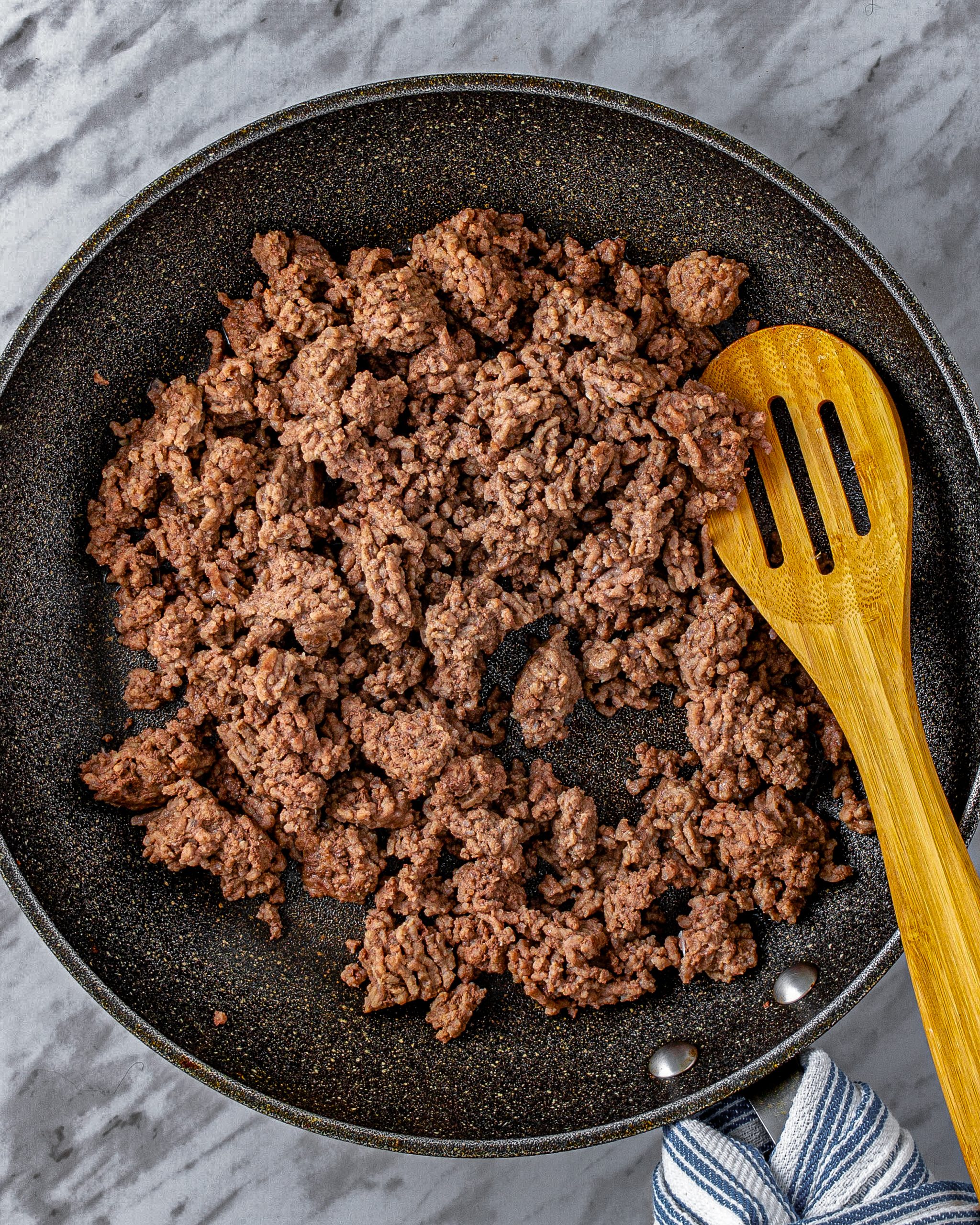 In a large skillet over medium heat, add the ground beef seasoned with salt and pepper and cook until brown.
