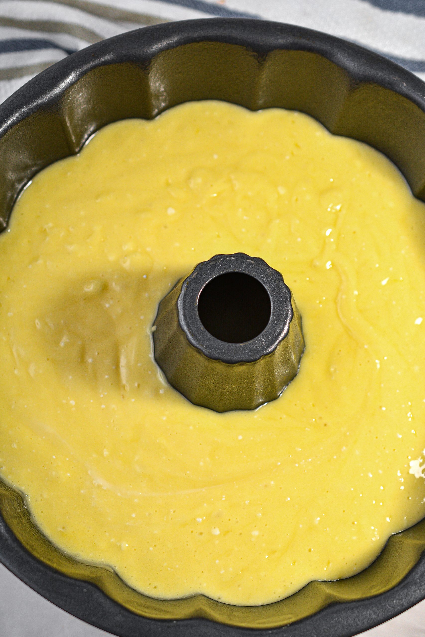 Pour the batter into a well-greased bundt pan.