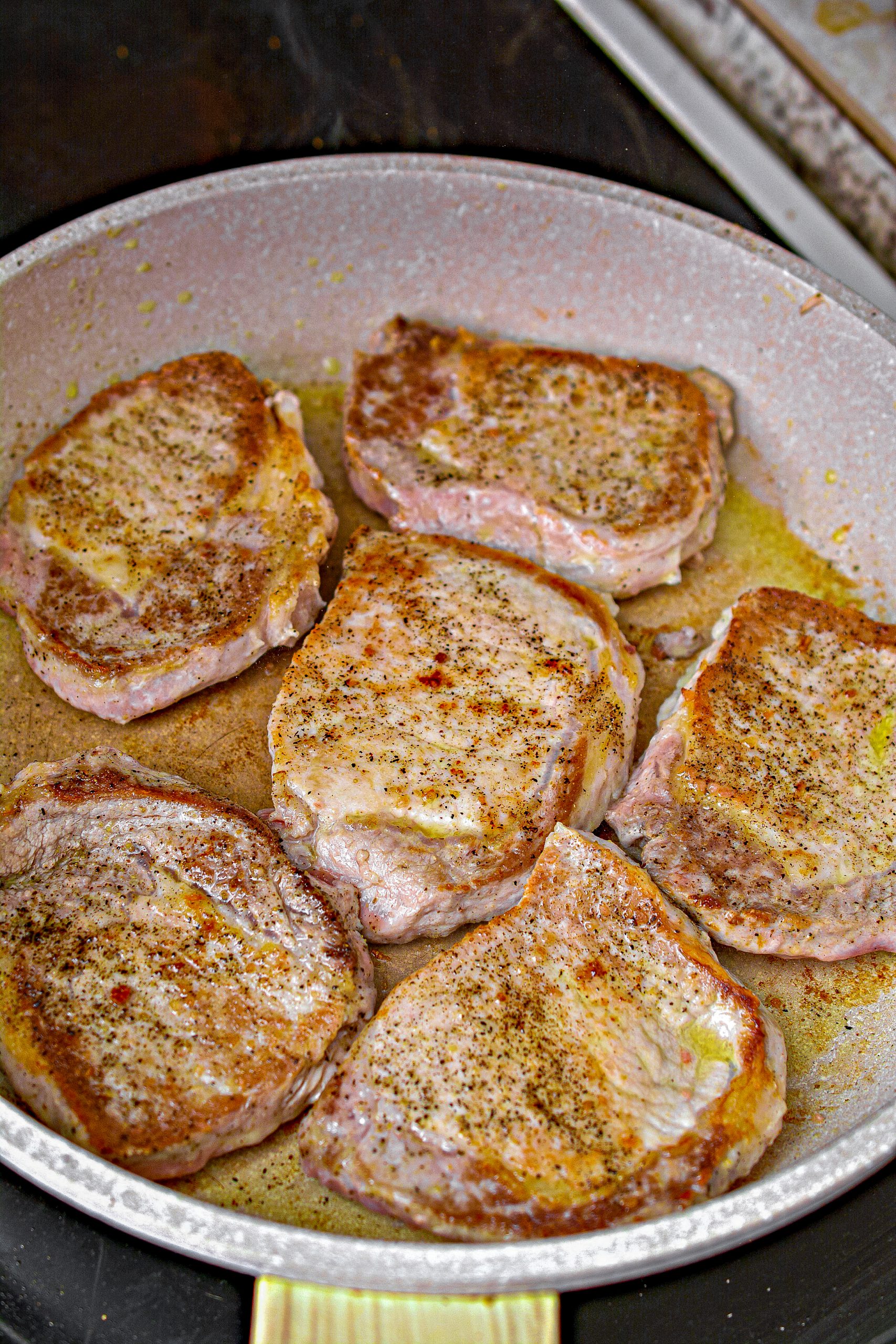 Add the pork chops to the heated skillet and brown on both sides. Remove, and set aside.