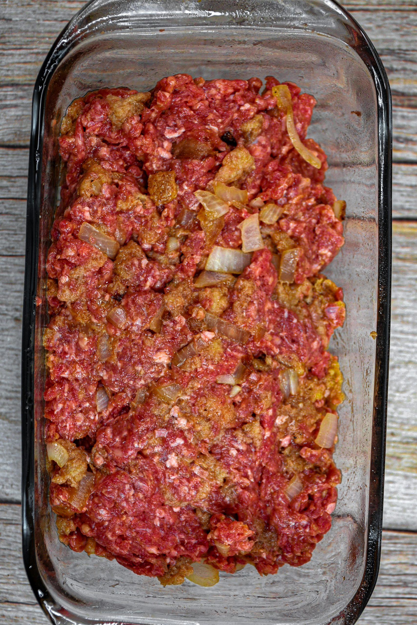 Form the loaf. Transfer the meat loaf into the prepared loaf pan. Place in the oven.